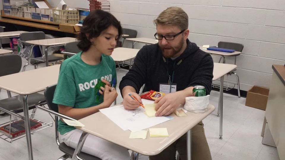 Jake Heagy helping a student during Star Wars Days . 