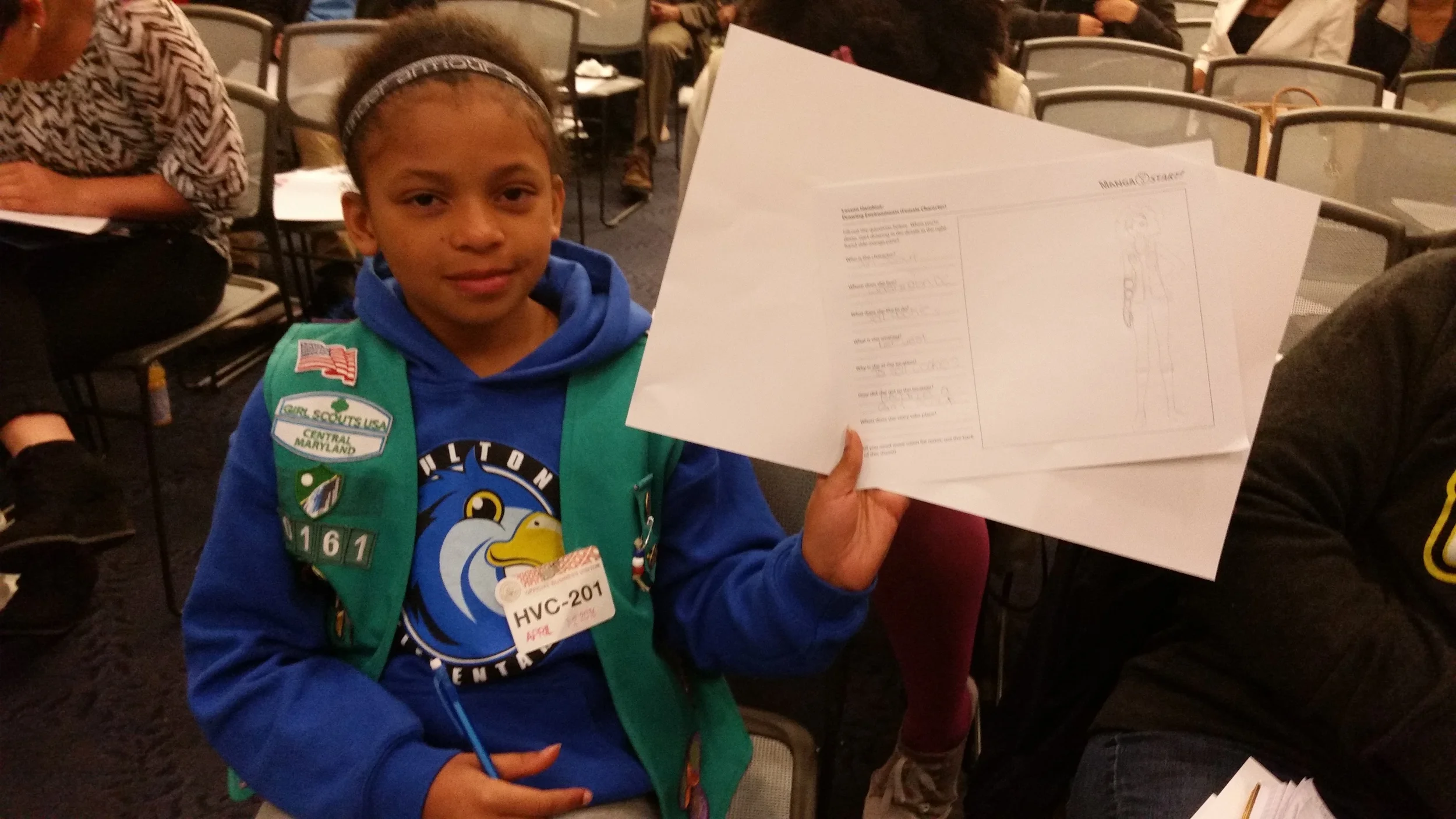 A girl scout shows off her artwork. 