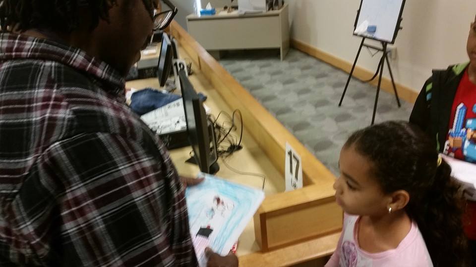 A student shows Darren Soto her work. 