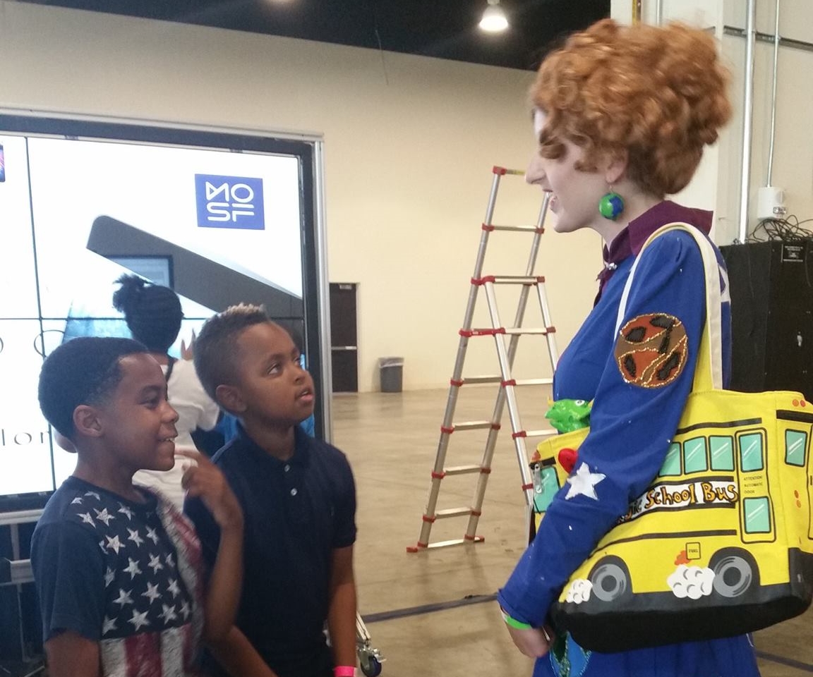 Children speak to a Ms. Frizzle cosplayer about the Magic School Bus episodes they've seen.