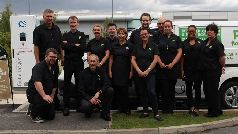 The PJ taste team posing with one of the business's electric delivery vehicles