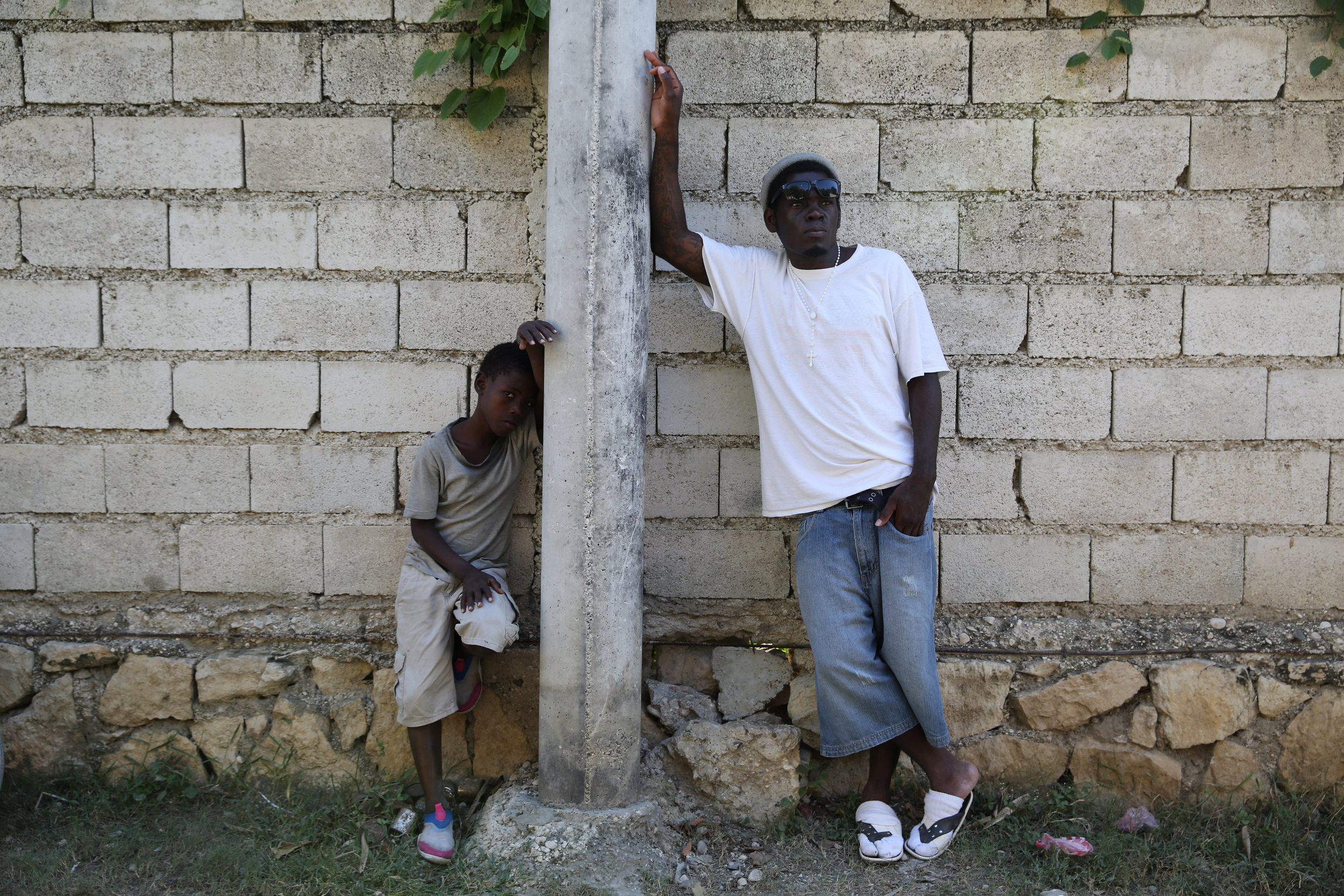   Johnnie Grandjean stands outside of the accommodation center with a neighbor. “I did three years in prison and six months in immigration. Since I got deported, it’s good to be in freedom so I could finally see the sun rise and be our and about doin