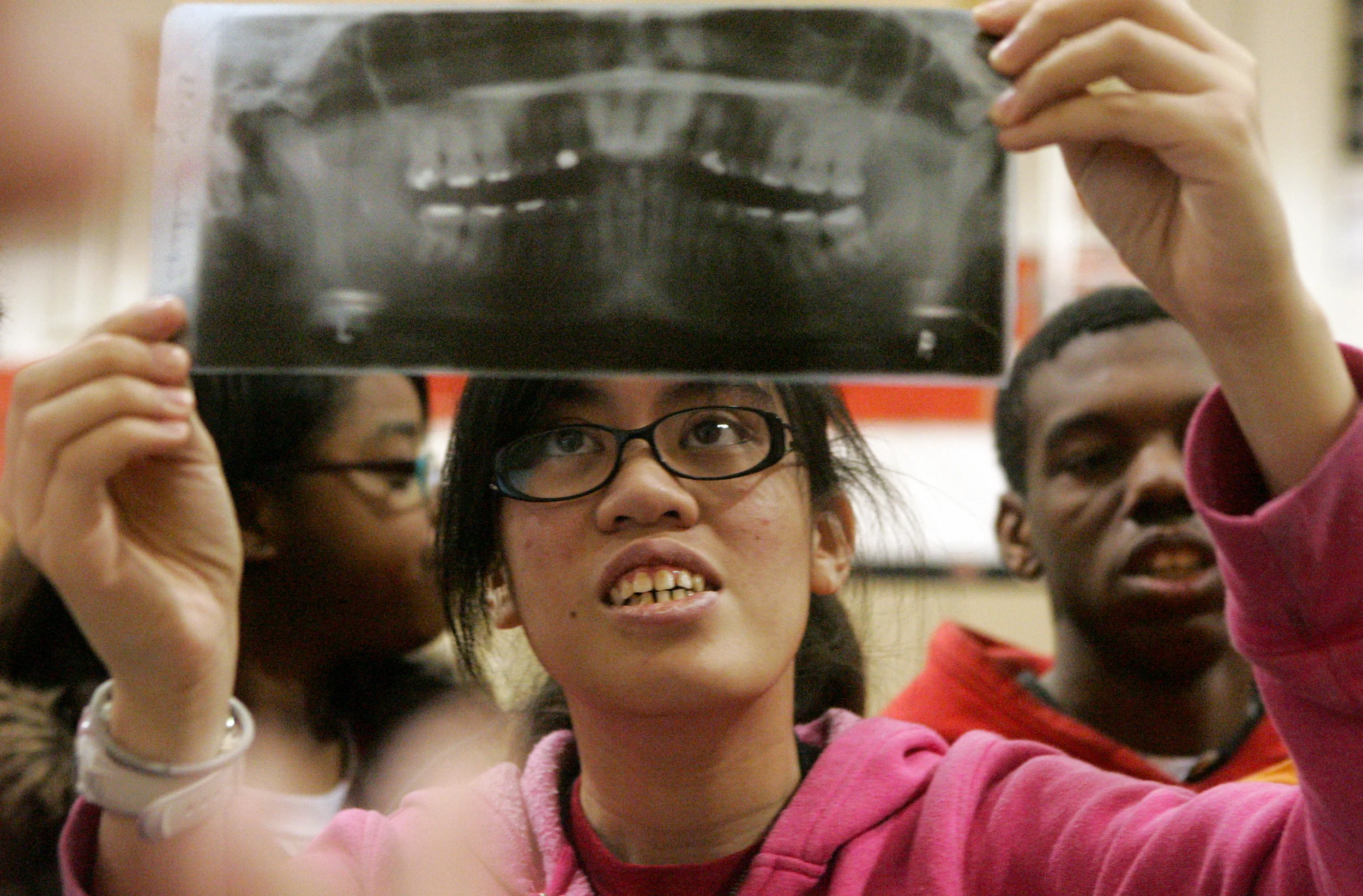  Illinois School for the Deaf senior Marianne Pangilinan examines a dental X-ray at the school. Ms. Pangilinan said, through an interpreter, that she had never seen one up close and was fascinated by it. The X-ray was one of the items brought by Jenn