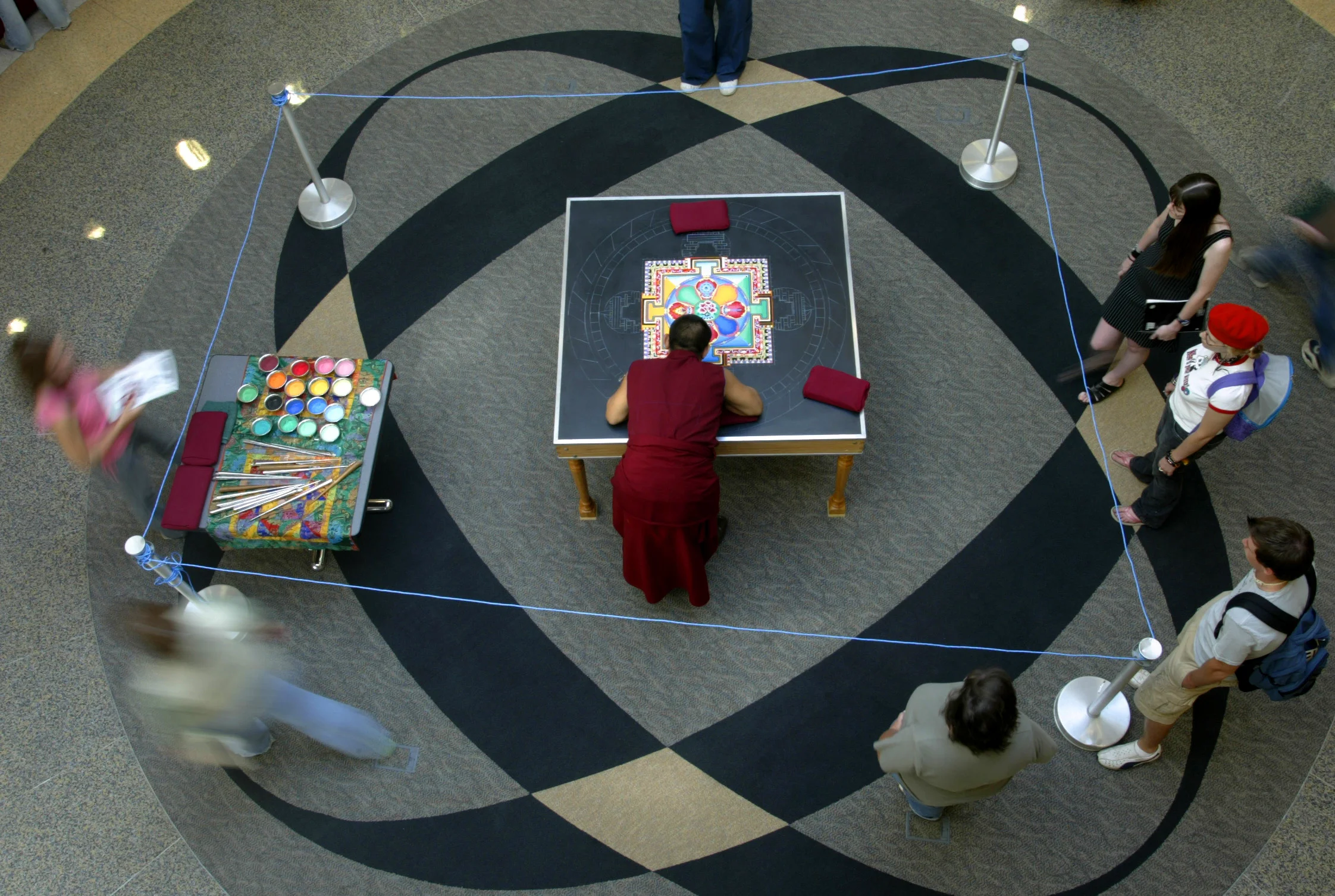  A Buddhist monk from the Drepung Loseling Monastery in India works on a mandala sand painting in the atrium of Illinois College’s Parker Science Building in Jacksonville. Eight monks from the monastery did the work over four days at the college. Upo