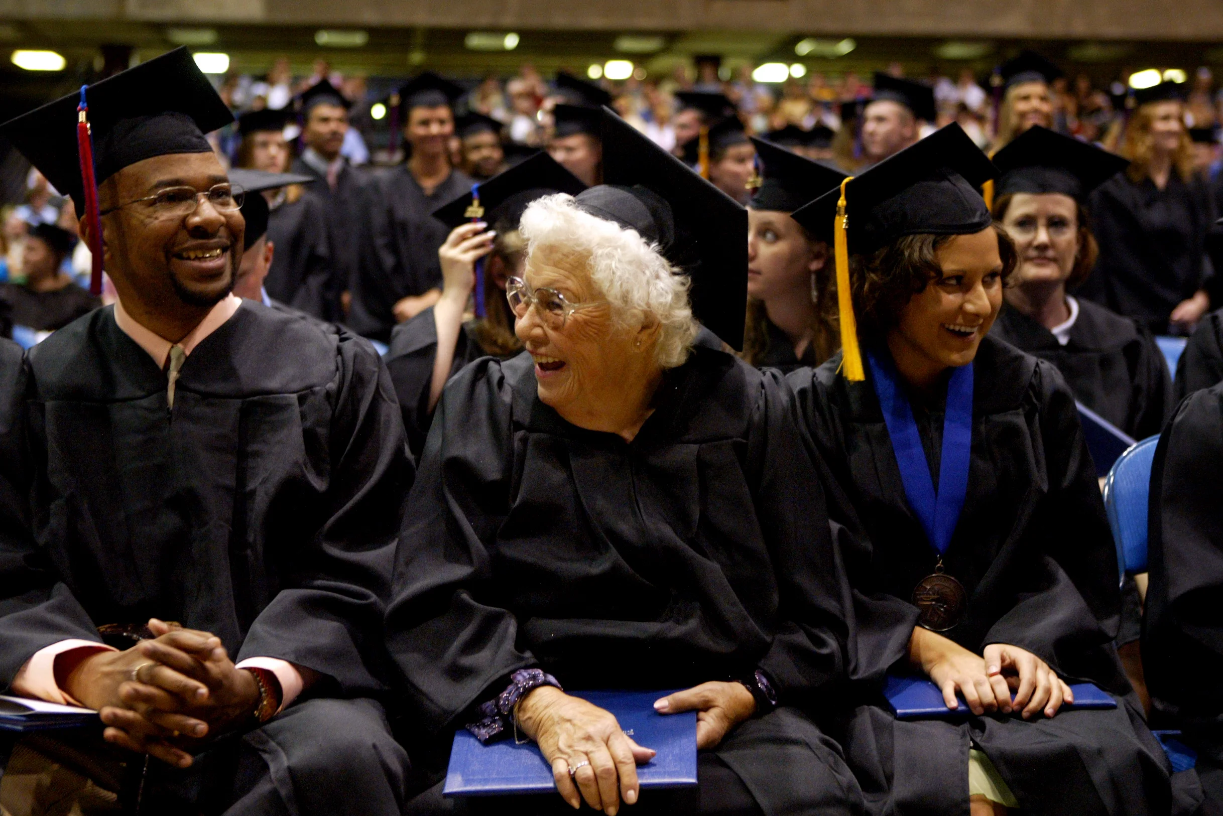  Mae McMillen sits with fellow Lincoln Land Community College graduates Randel Britton (left) and Regina Rusciolelli at the college’s commencement in Springfield. At age 76, she is the second oldest person to graduate from the school and the oldest t