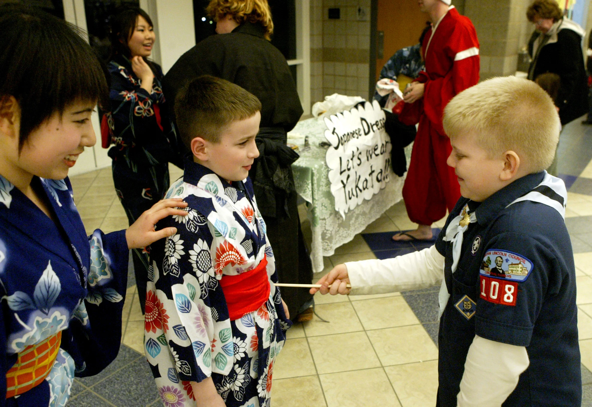  Noah Bridges, 8, (right) had been wearing a yukata — a traditional Japanese style of dress — only moments earlier, but that did not stop him from poking fellow Cub Scout Mason Pohlman, 9, with a chopstick and giving some good-natured teasing. Aki Ya