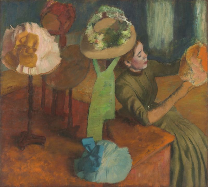 The Millinery Shop, by Edgar Degas.  Along with his painting, the Milliners, this painting illustrates a millinery shop, this time showing a customer examining a hat.