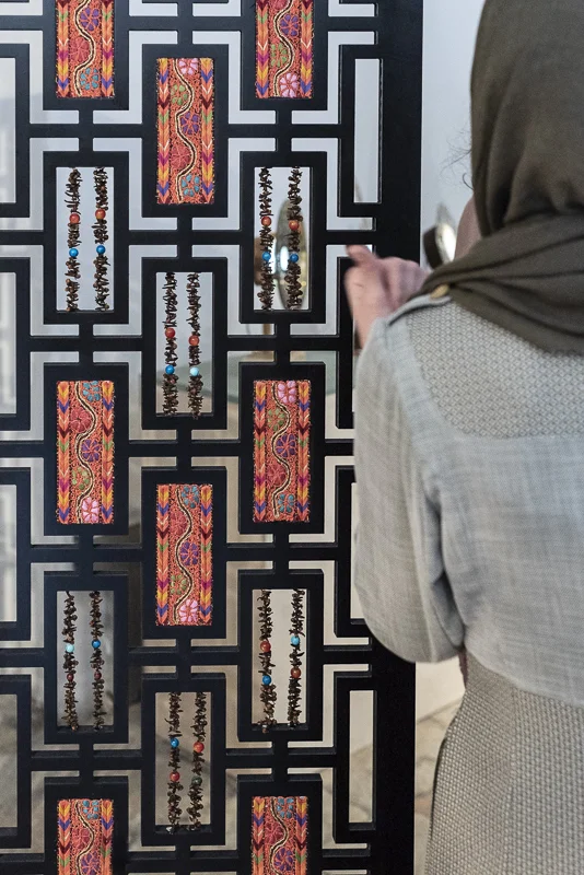 Young Palestinian designer standing by her work
