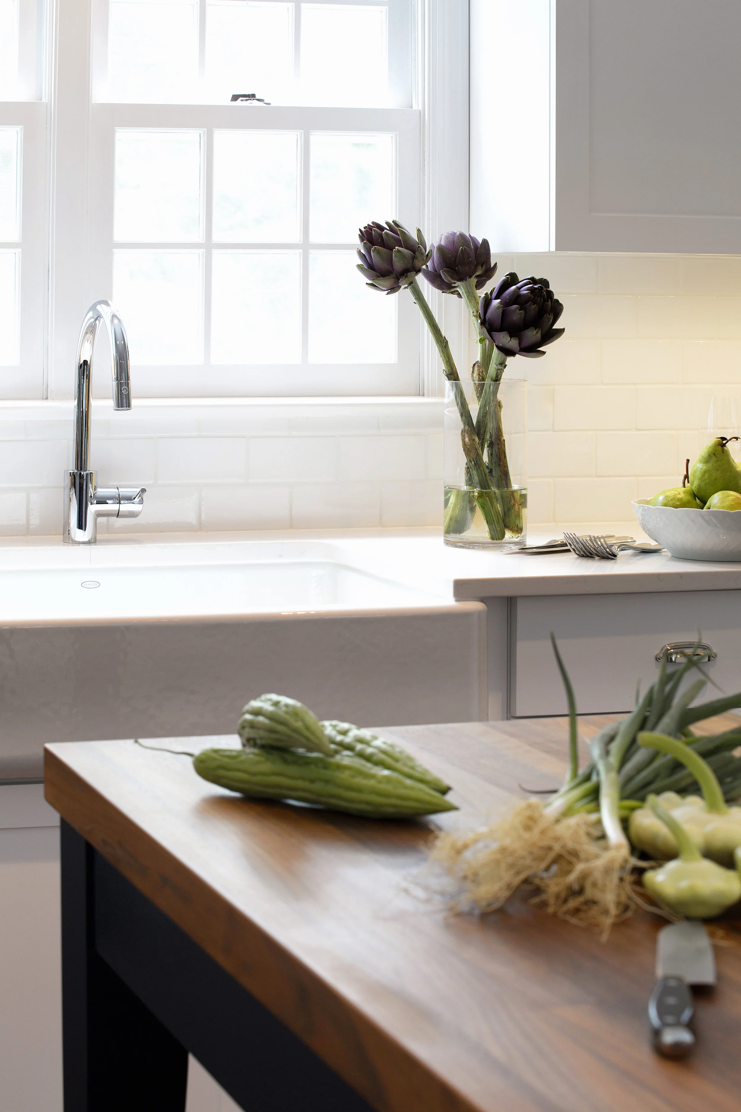 A Kohler farm sink is key to the home’s country farmhouse aesthetic. Countertops look like Carrera marble but are actually quartz, selected for its durability. 
