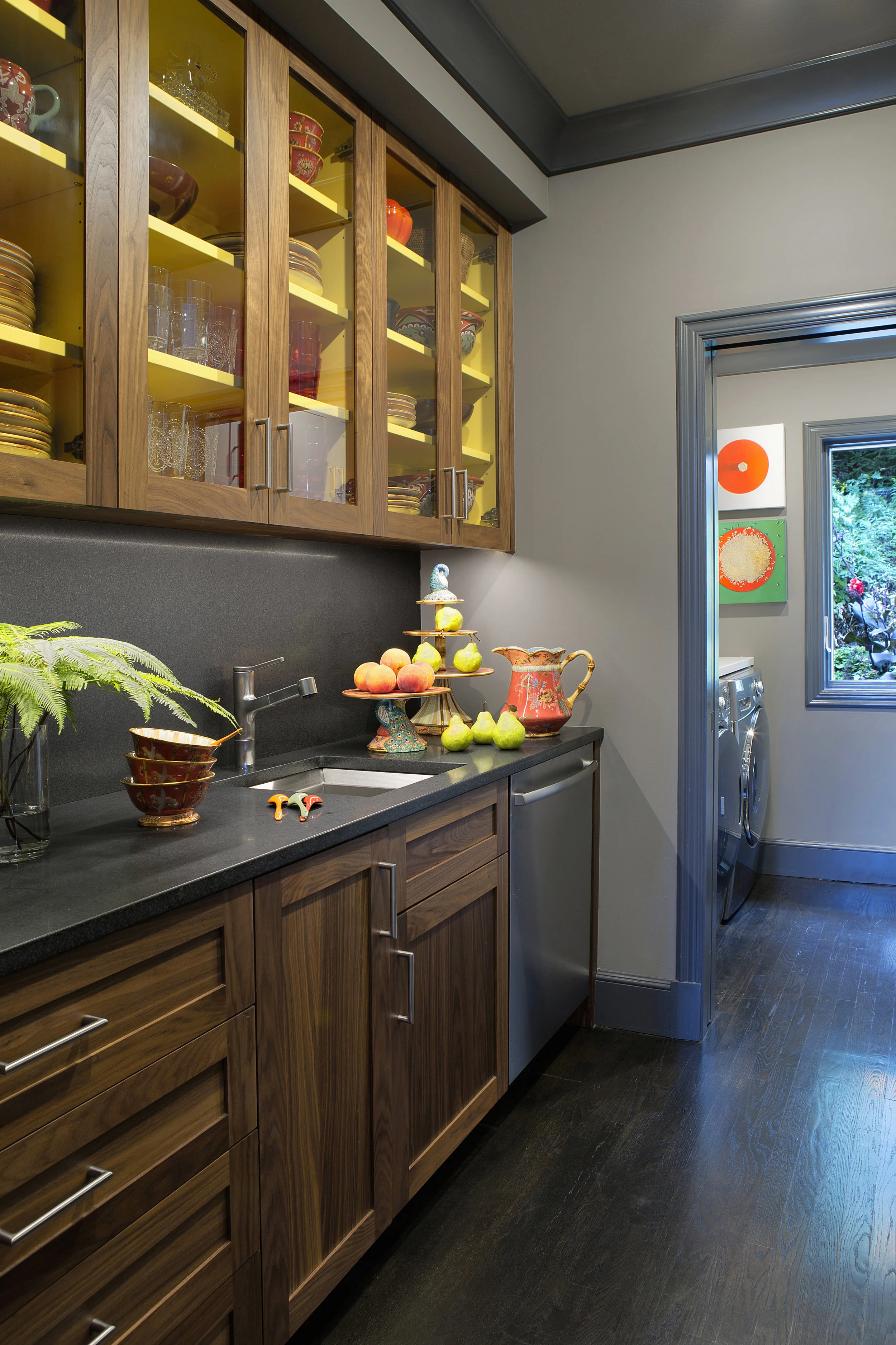 We reconfigured a large, existing laundry room to provide space for a pantry as well as laundry facilities. Honed black countertops with matching backsplashes carry over from the kitchen design. A cleanup sink, icemaker, and extra dishwasher make entertaining easier. 