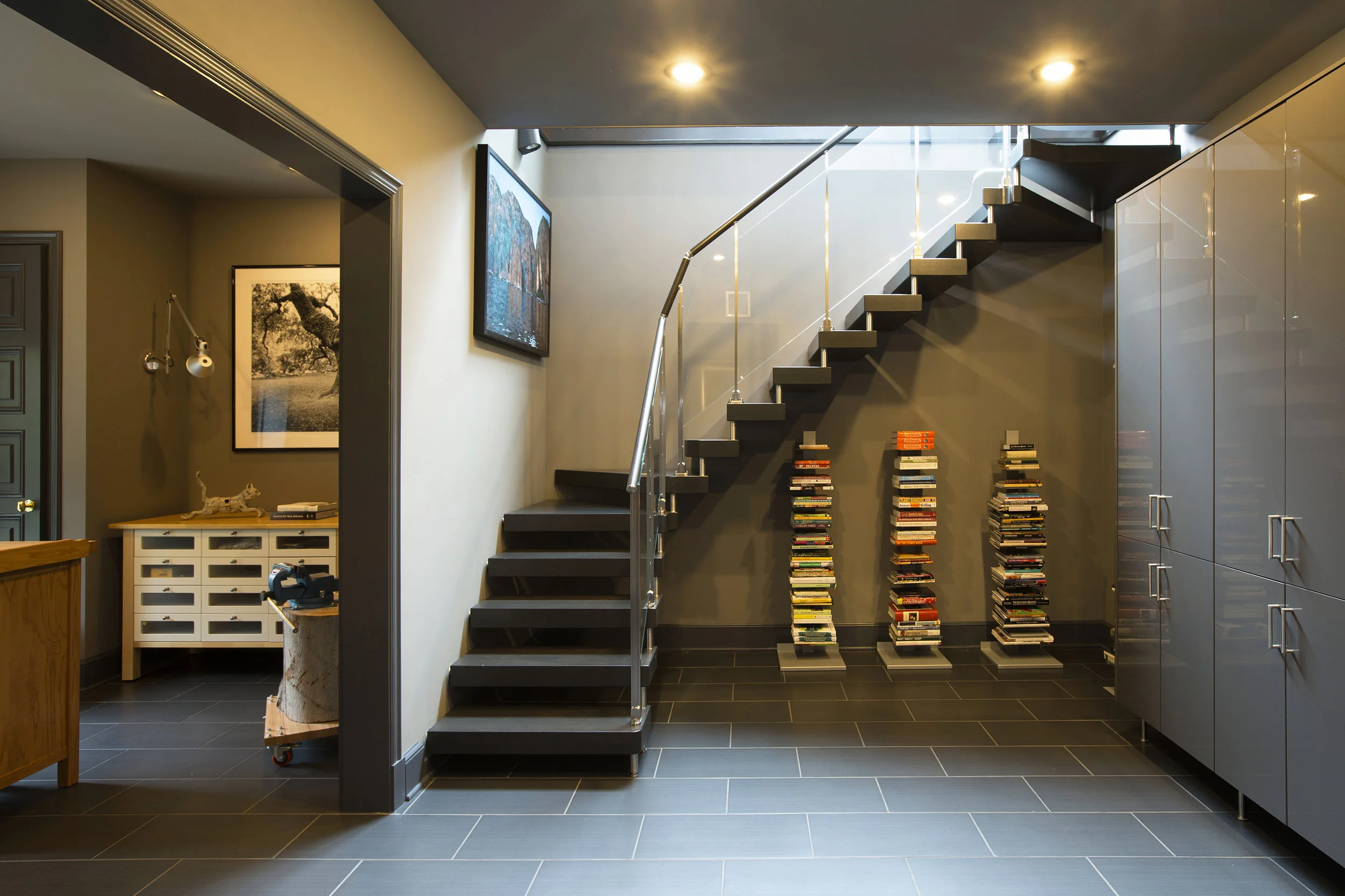 A new Italian floating staircase leads down to a rec room and full bath for the pool area. The wood risers are stained to match the oak flooring in the kitchen.