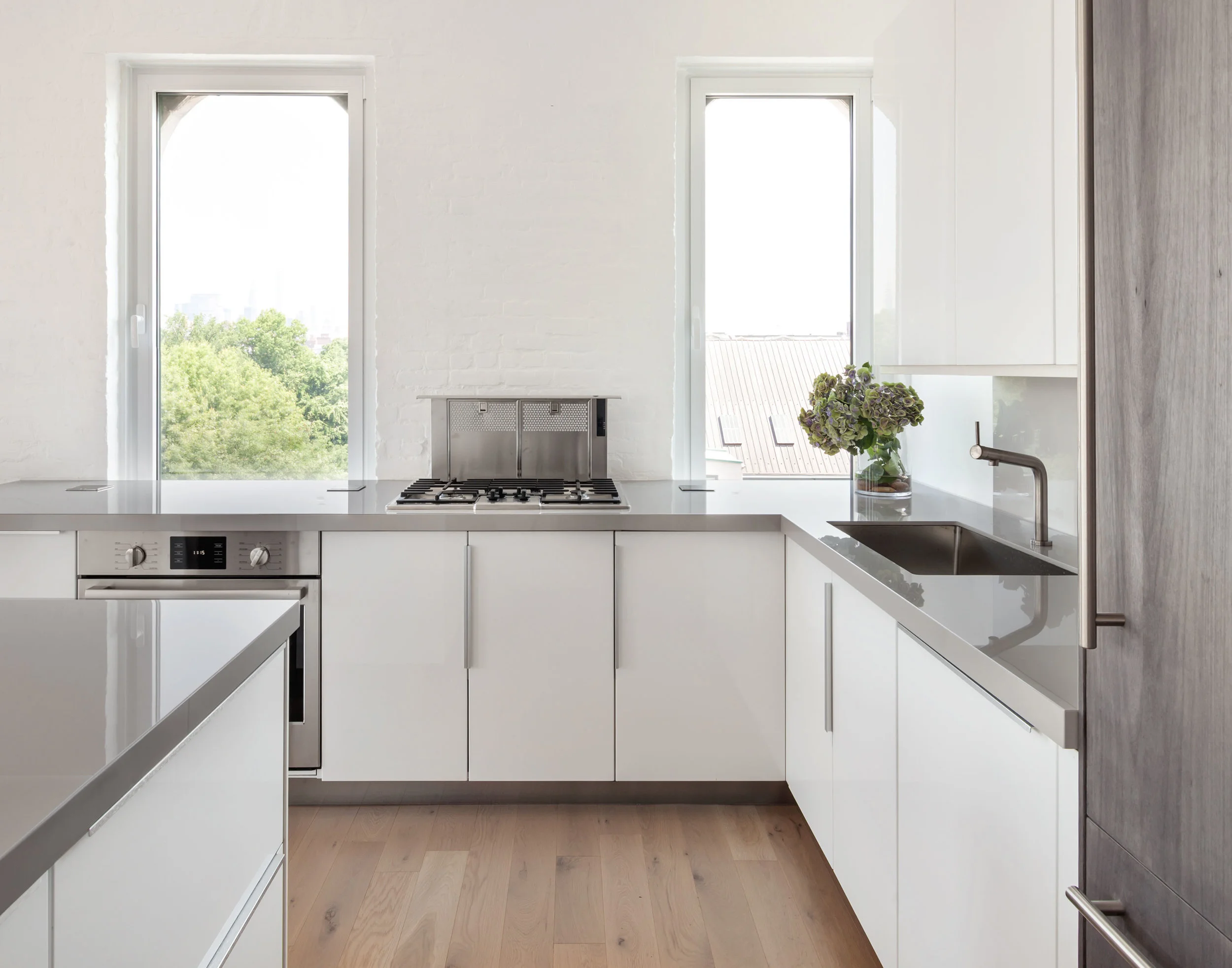Combining cost effective IKEA cabinets with durable, high performance countertops and appliances, weetu created a dream kitchen on a dime. A retractable countertop vent supports a minimal, clean appearance.