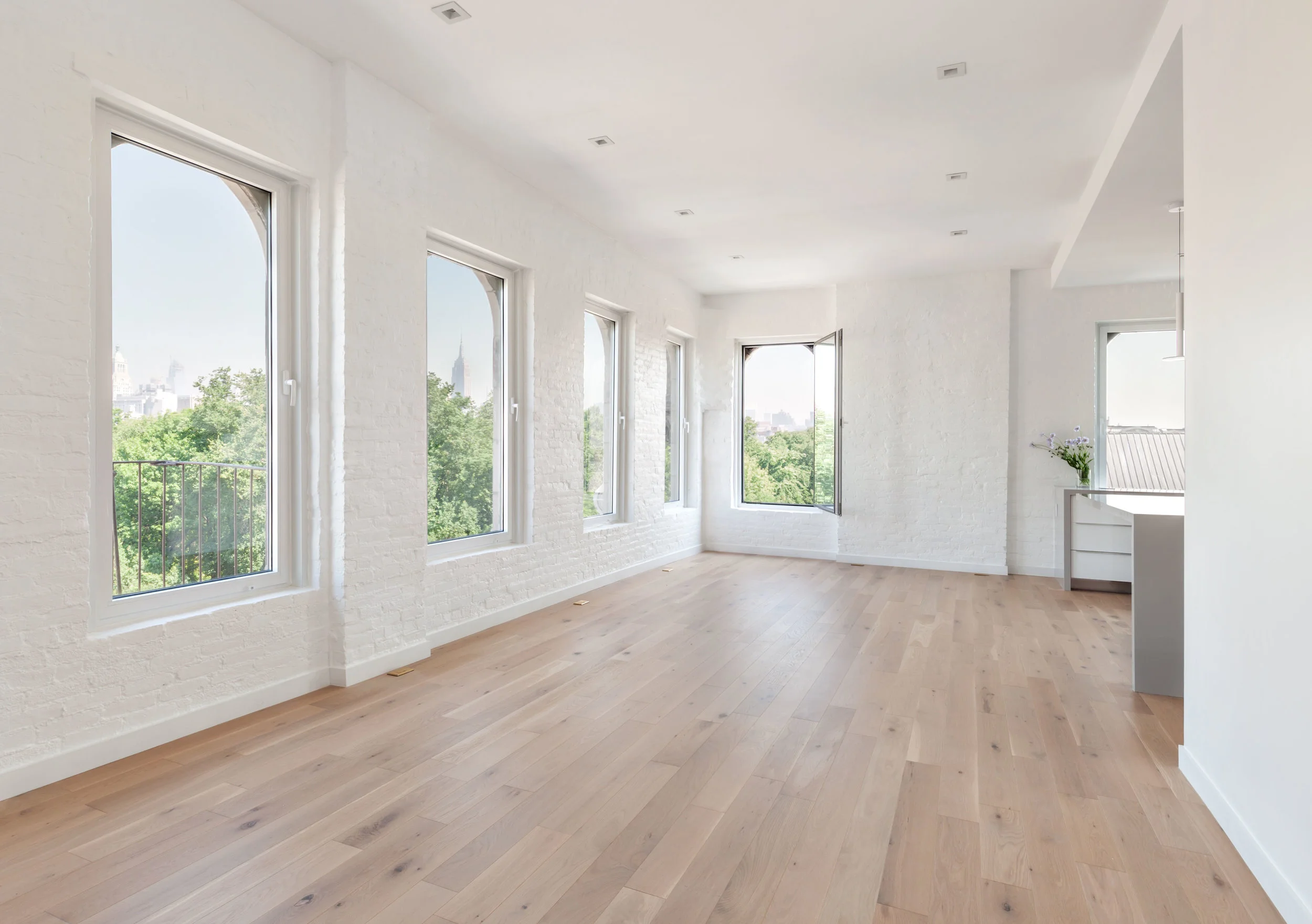 Warm, oak floors and white painted brick walls brighten space, providing a timeless, neutral canvas for years to come. New windows enhance the sweeping skyline views.