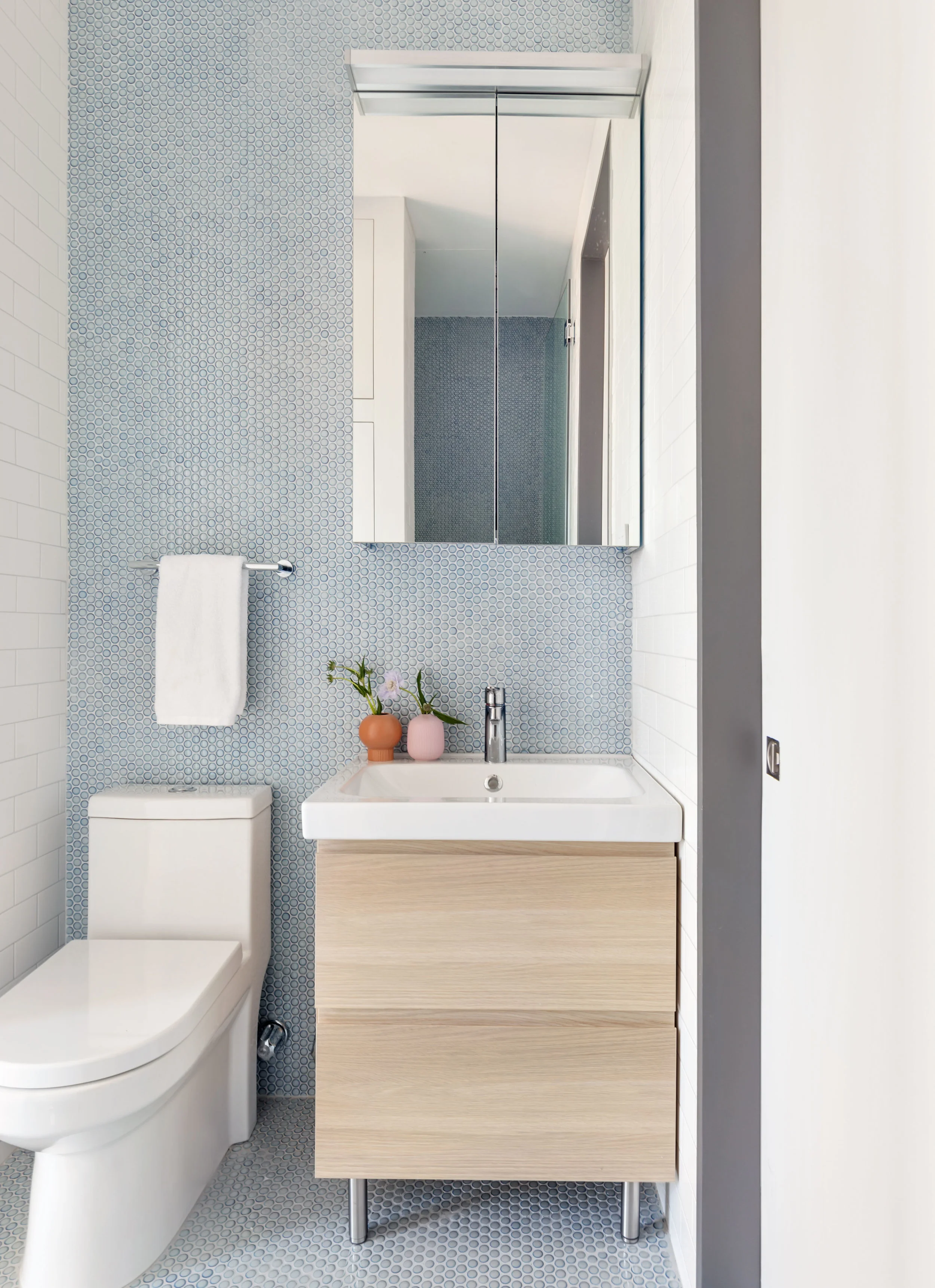 Guest bathroom with blue penny tile walls and floor. 