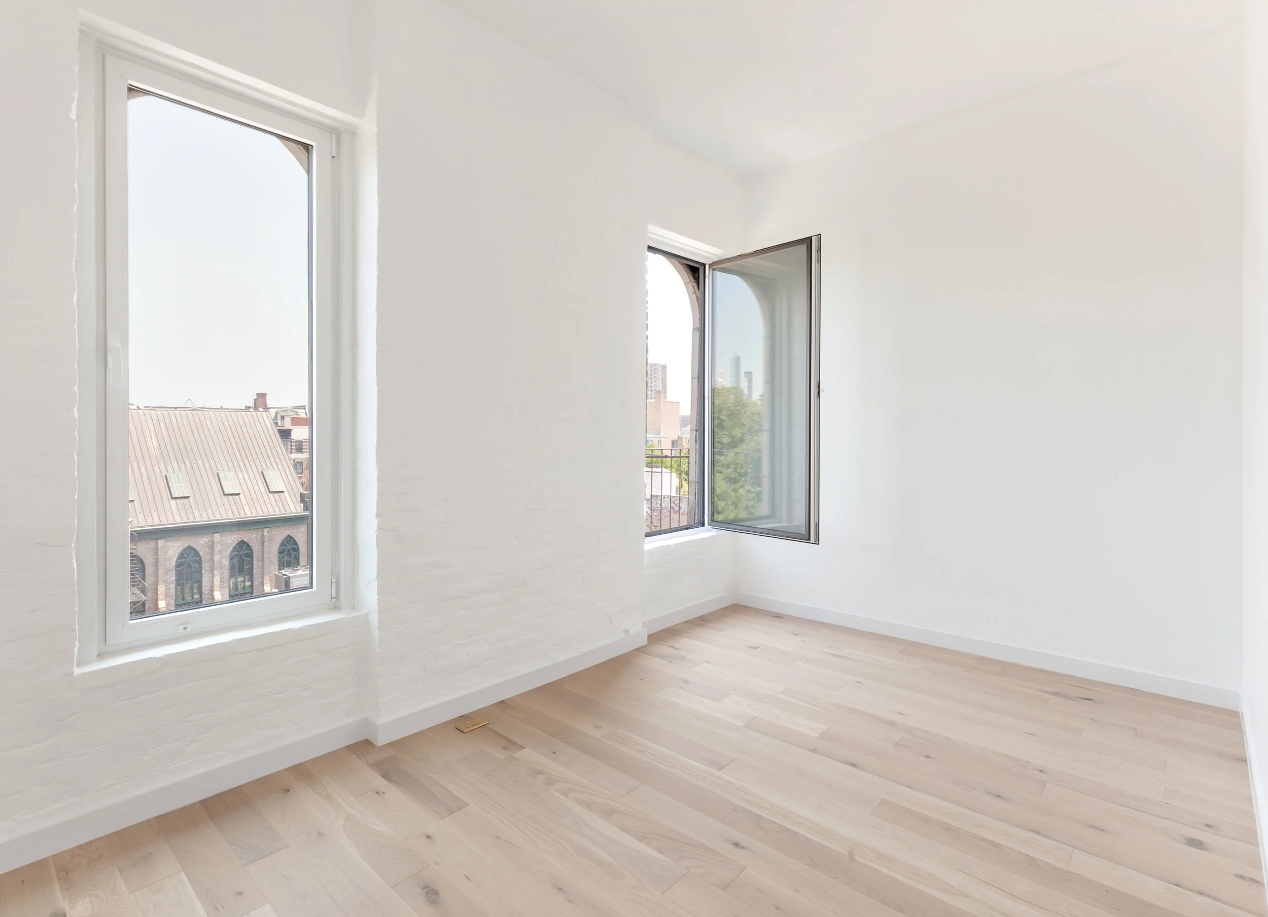 Guest bedroom with painted brick walls and European oak floors.