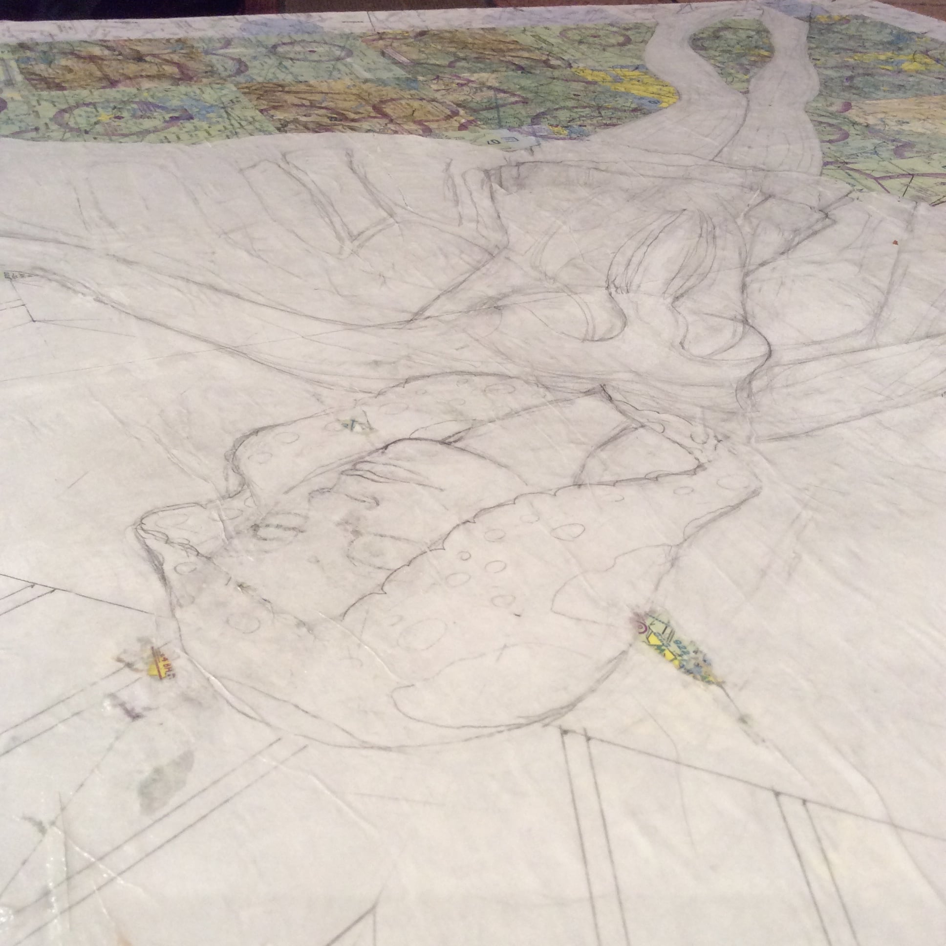 Figure drawing adhered to the map surface. I have seen this technique used before, but I had not tried it on this scale piece. There is more texture than I am used to working with, but success!