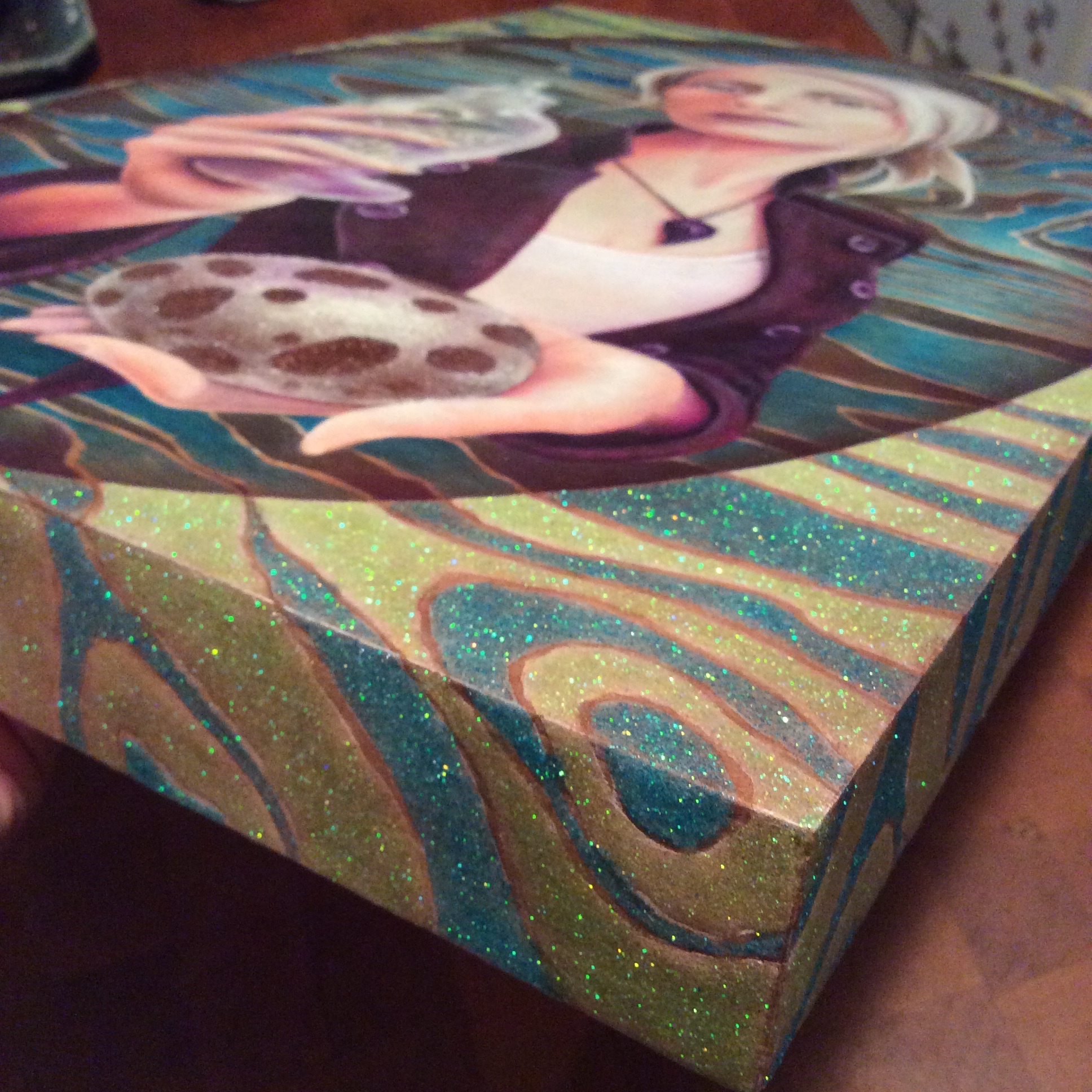A layer of white and Phthalo Turquoise, then a layer of glitter mixed with pouring medium, leaving the wood grain lines exposed. 