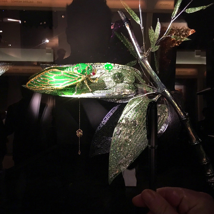 Jewelled cicada sculpture by Wallace Chan, in jadeite, diamonds and emeralds. Note the scale of the hand in the foreground to the piece itself.