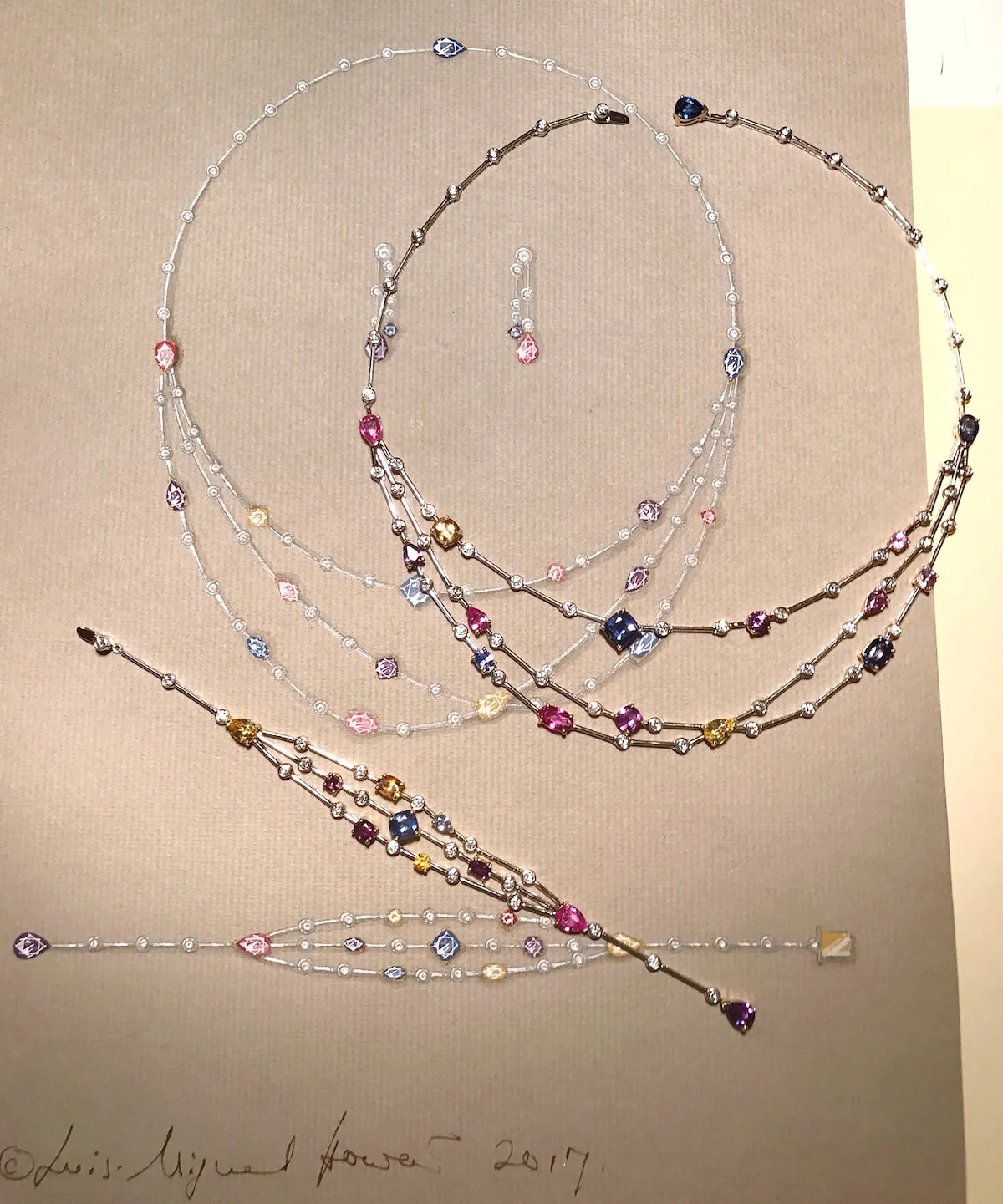 The multi colour sapphire and diamond bracelet and earrings shown next to their original drawings.