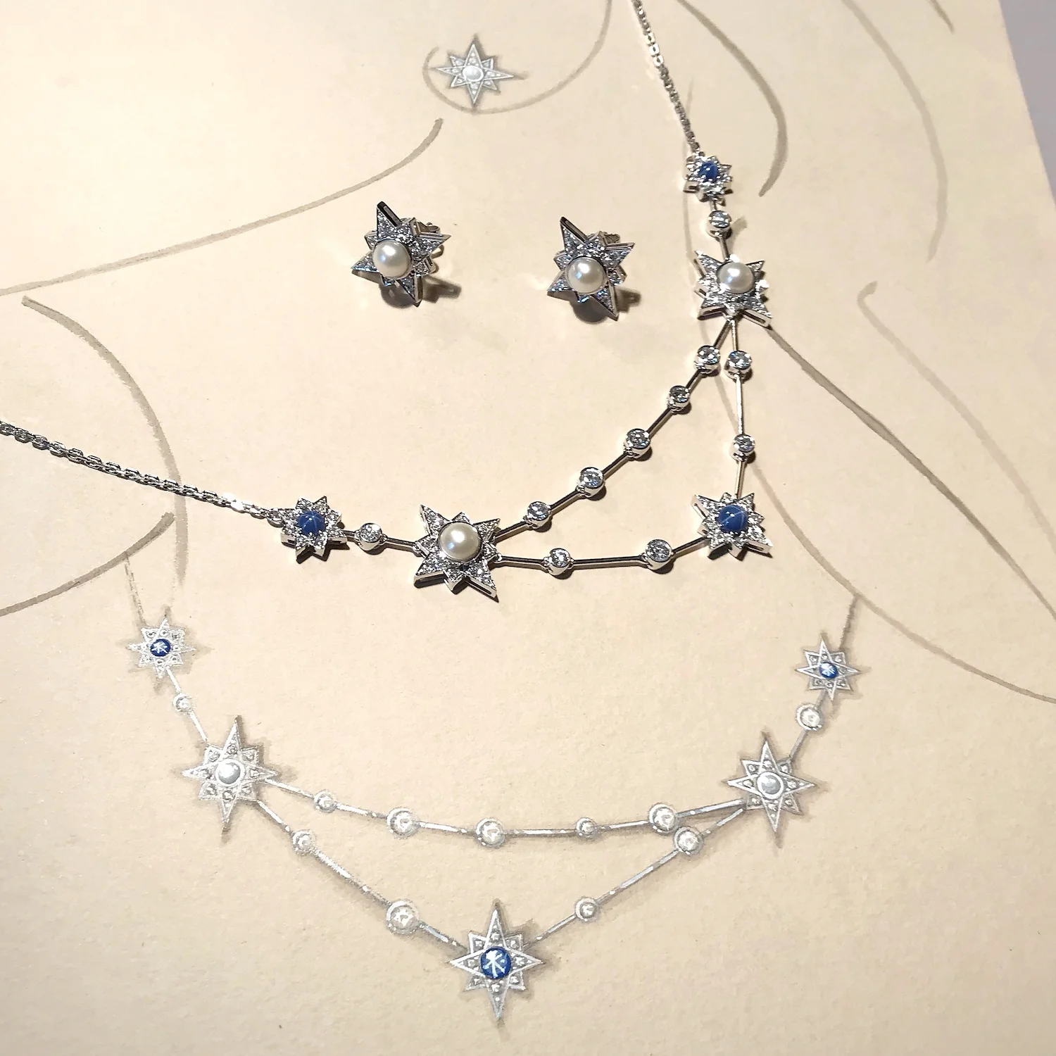 A snapshot of the Constellation necklace set with pearls, diamonds and star sapphires. It is shown with its working drawing in gouache and Chinese ink.