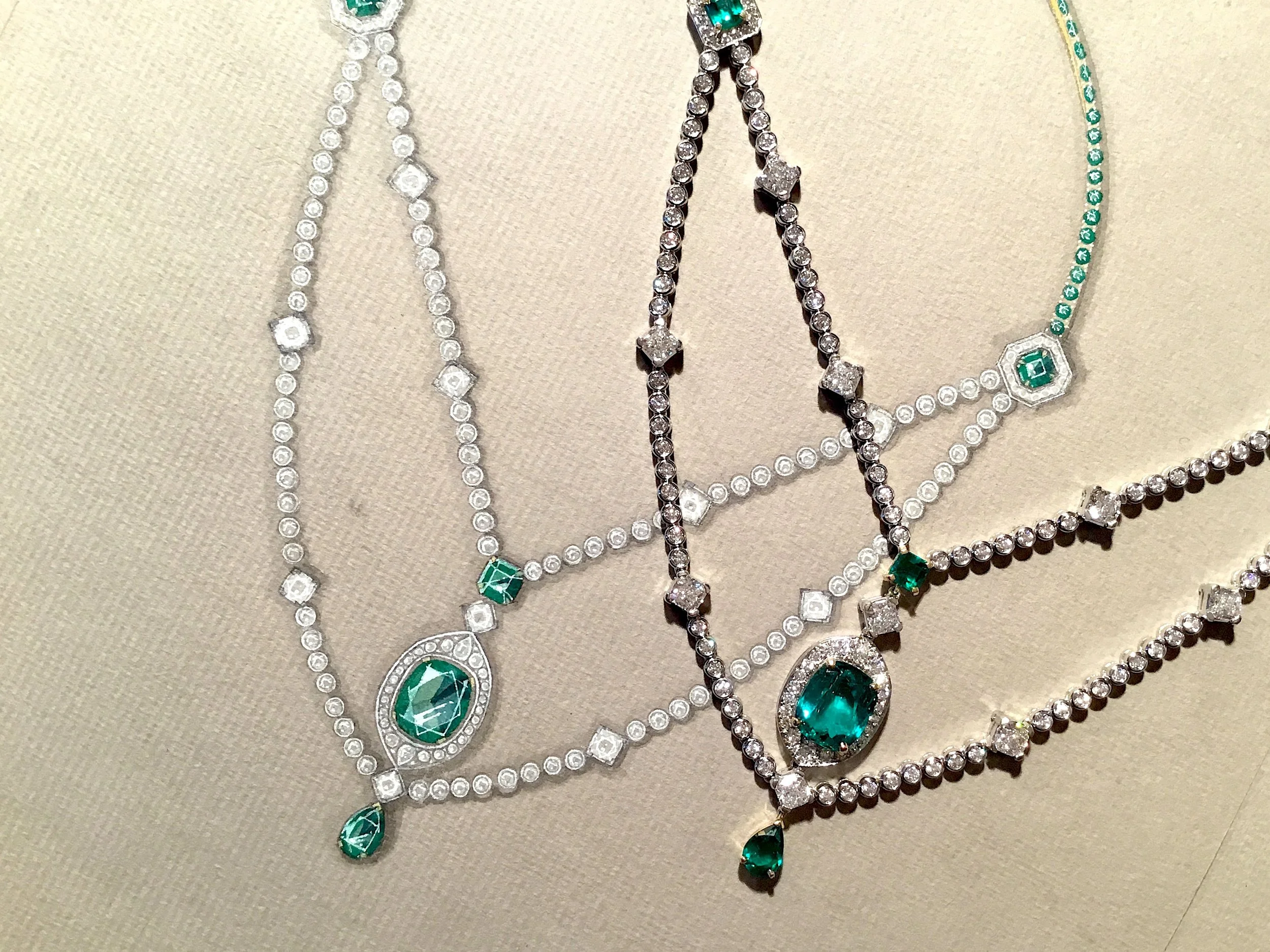 An emerald and diamond necklace, pictured next to the original working drawing.
