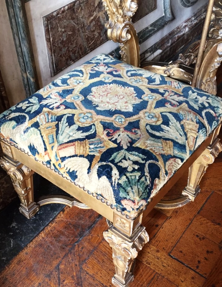 An upholstered stool in the Mars Salon. 