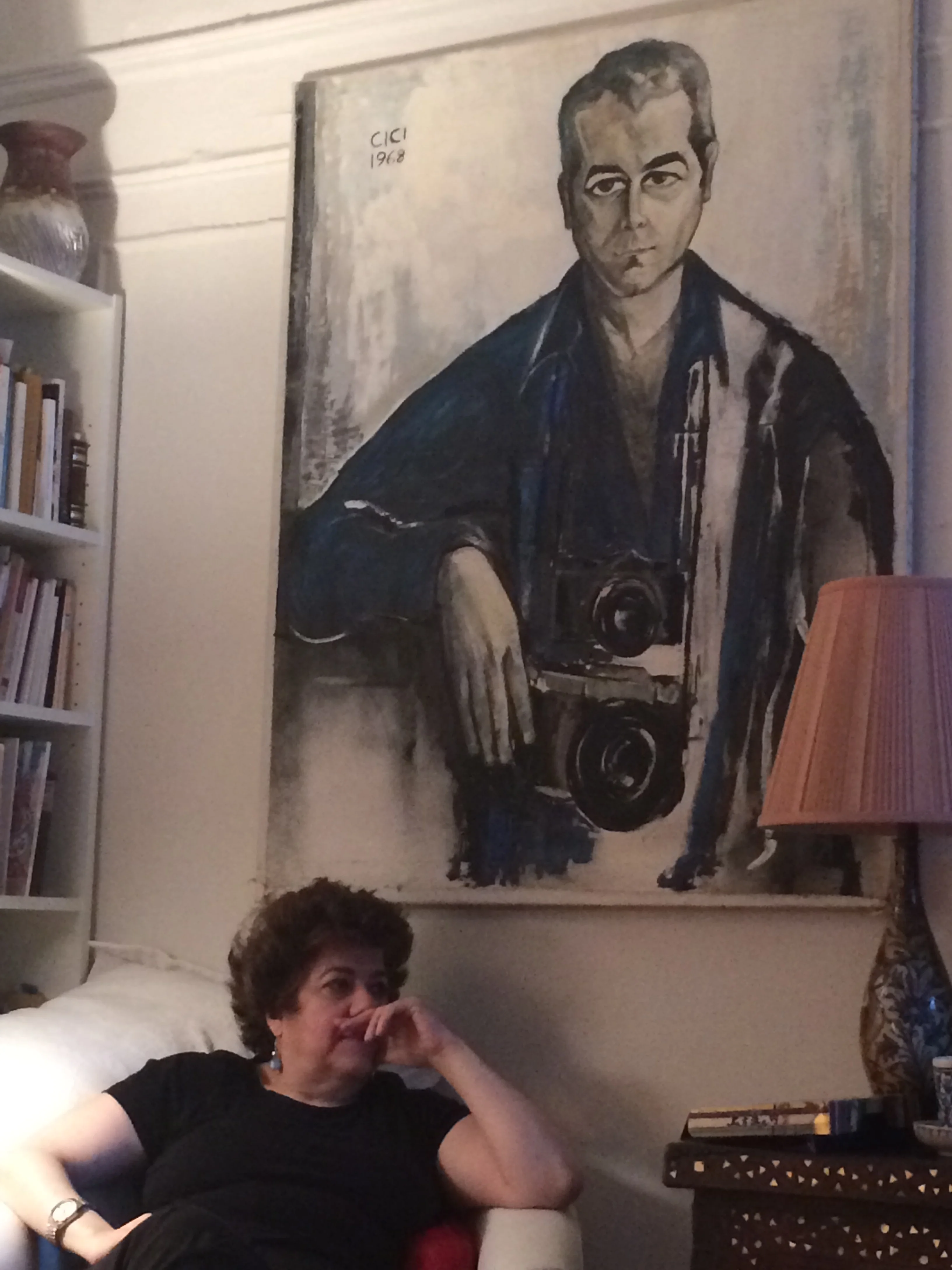 Lola Koundakjian, sits beneath a portrait of her father in her New York City home. Photo courtesy of Koundakjian.