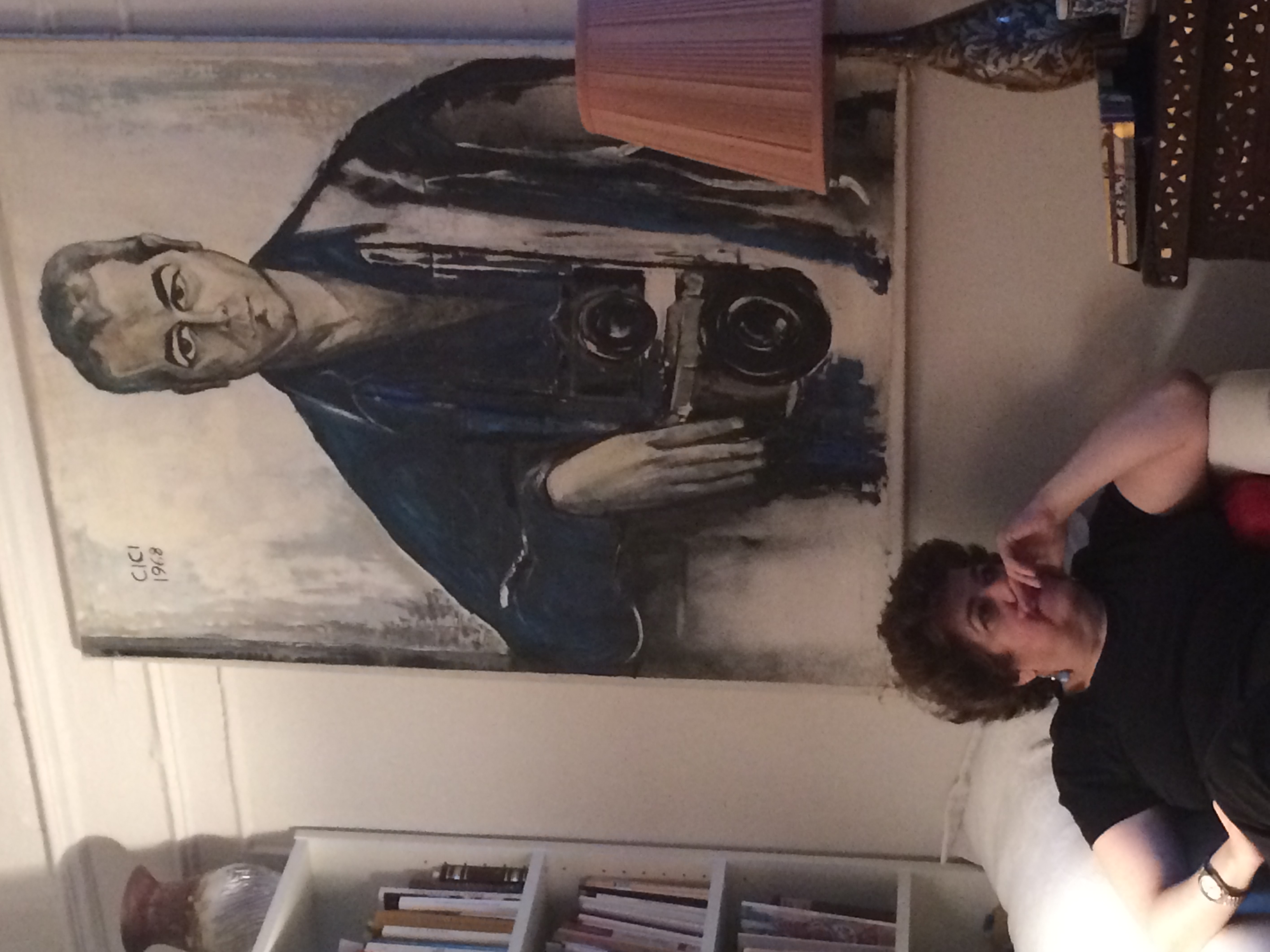 Lola Koundakjian, sits beneath a portrait of her father in her New York City home. Photo courtesy of Koundakjian.