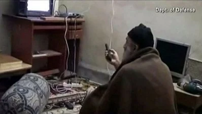 Osama bin Laden watching TV at his compound in Pakistan by U.S. Federal Government. Licensed through Wikimedia Commons.