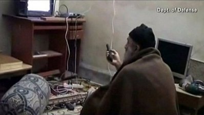 Osama bin Laden watching TV at his compound in Pakistan by U.S. Federal Government. Licensed through Wikimedia Commons.
