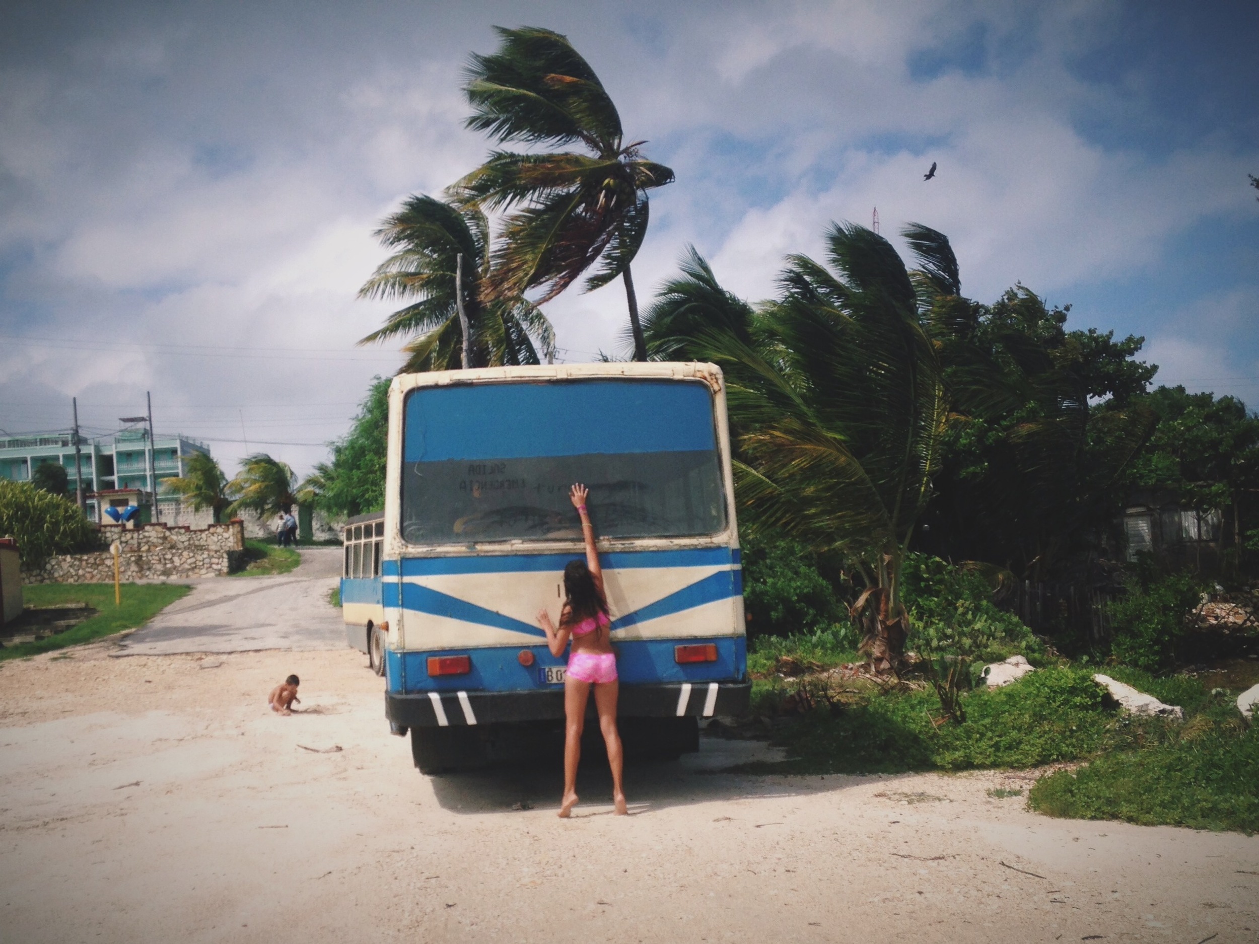 a girl writes in the dust on the back of a van in havana. photo credit: meghan dhaliwal for the alignist.