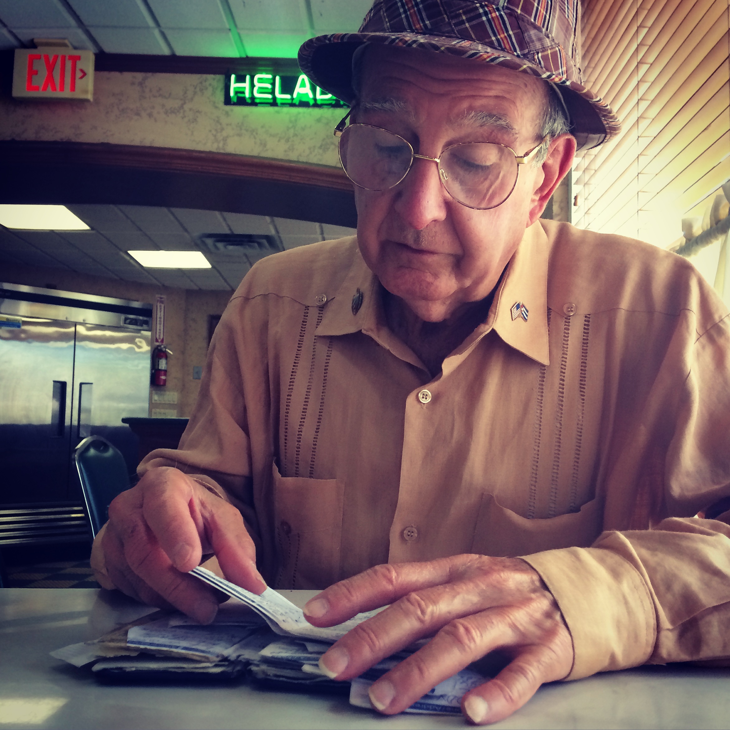 a cuban-american make looks through his documents at a miami cafe. photo credit: christine amario for the alignist. 