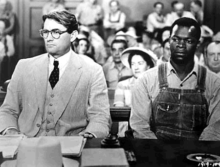 A promotional still from the film To Kill a Mockingbird (1962) with Gregory Peck and Brock Peters. Image via Wikimedia Commons. 