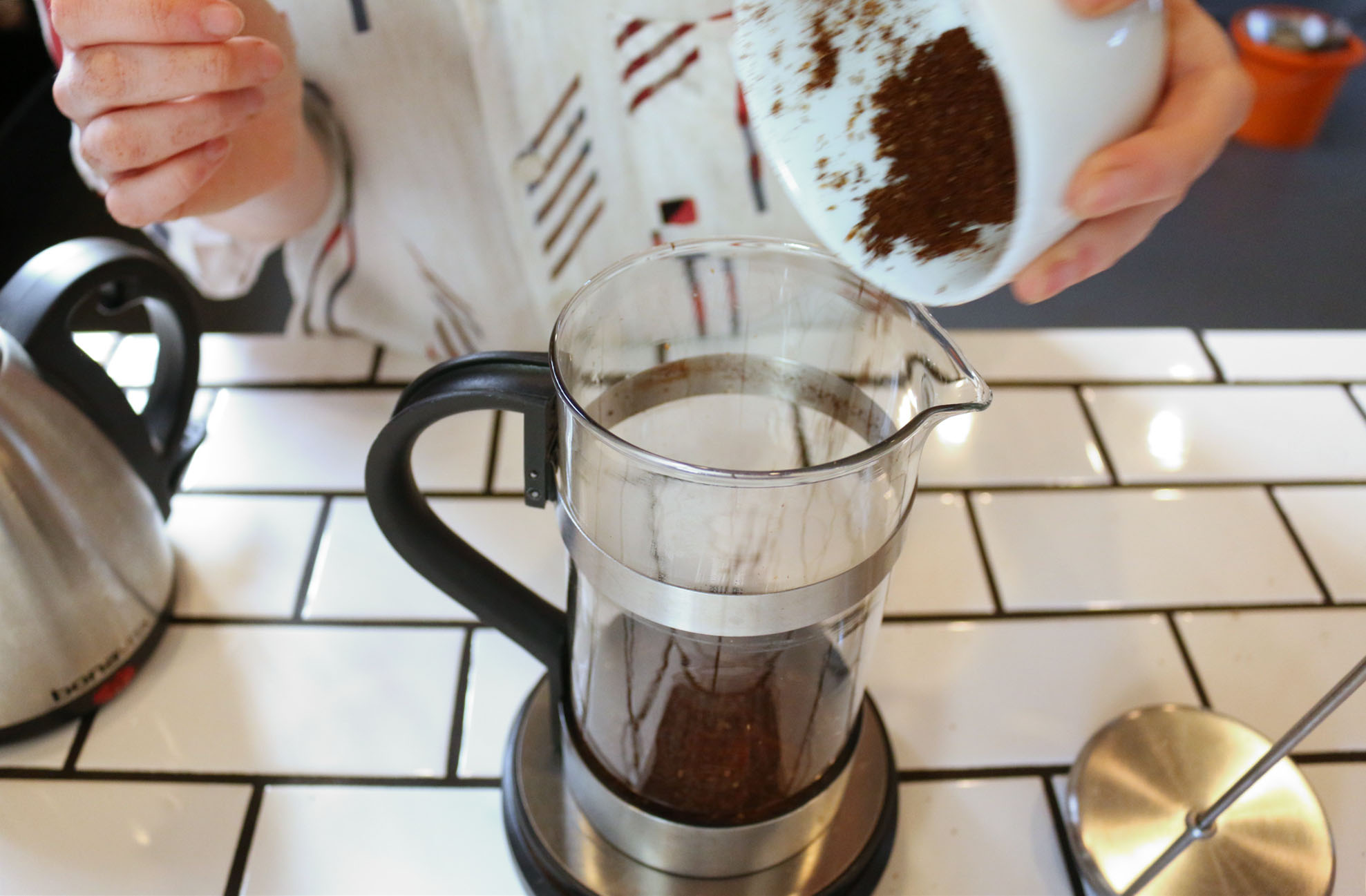 2. Grind coffee coarsely (texture of raw sugar) and dump into French press. Zero out the scale.