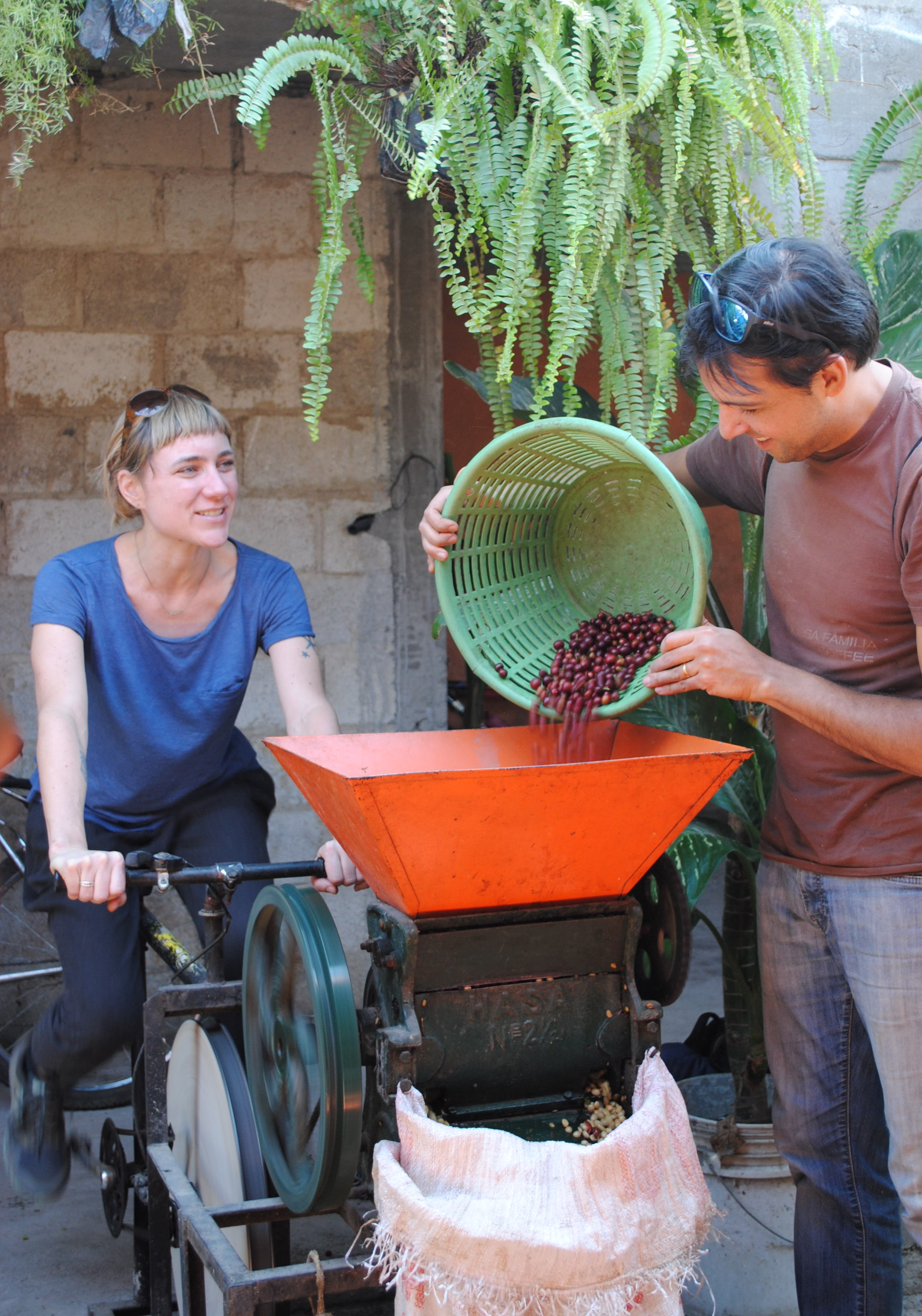 Grand Central Bakery's Jess Tannenbaum and Nossa Familia owner & founder Augusto Carneiro try out a bicycle coffee mill in Guatemala.