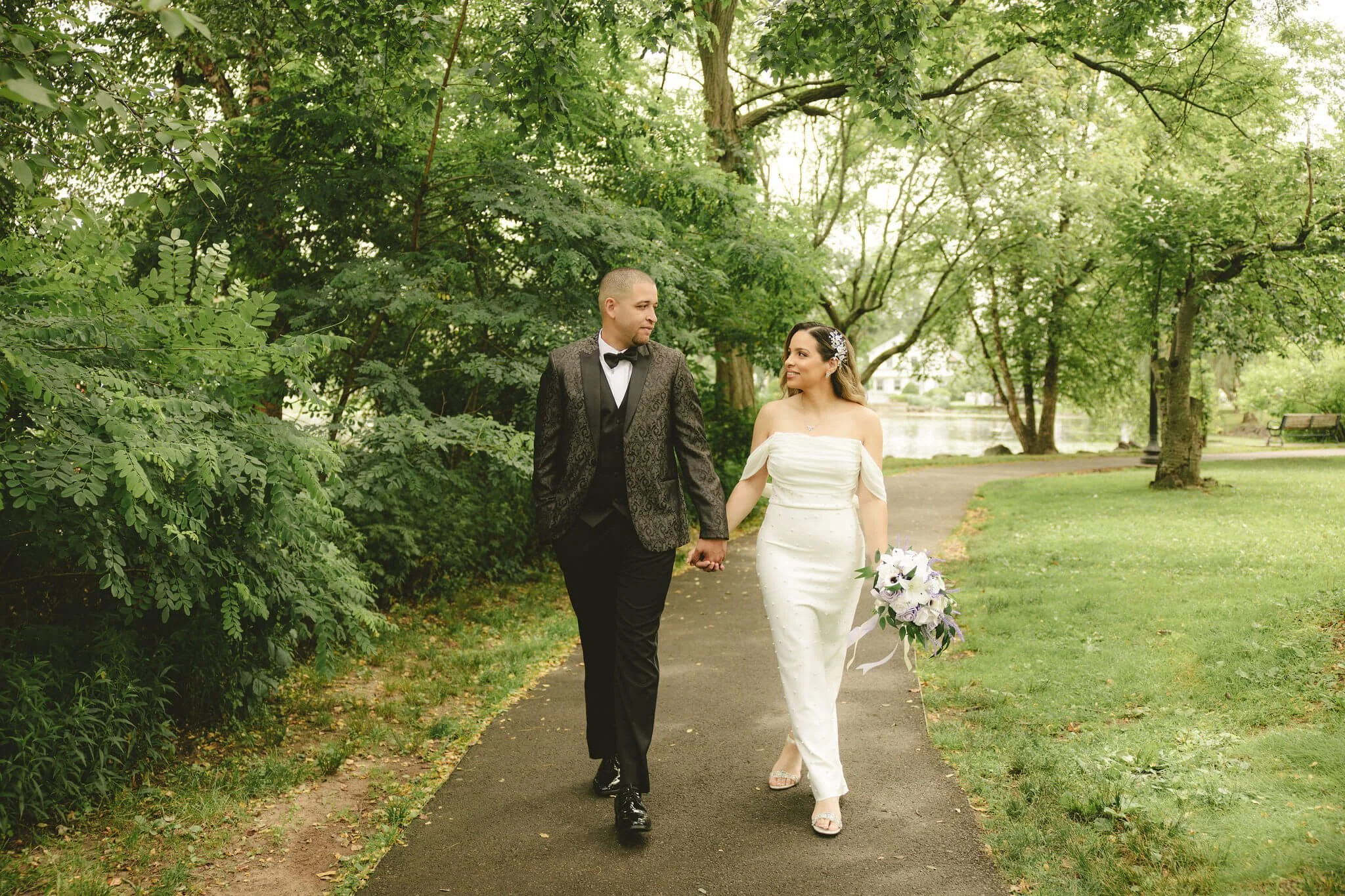 Newlywed couple walking hand in hand after their intimate elopement ceremony at Mindowaskin Park in Westfield, New Jersey.