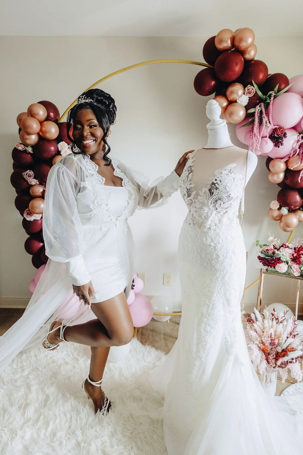 Kristie poses beside her lace wedding gown while getting ready for her wedding to Gillon.