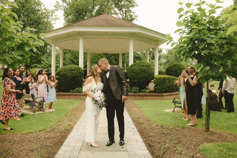 Sheila and Augustin share a kiss on the path to the gazebo at Mindowaskin Park in Westfield, NJ