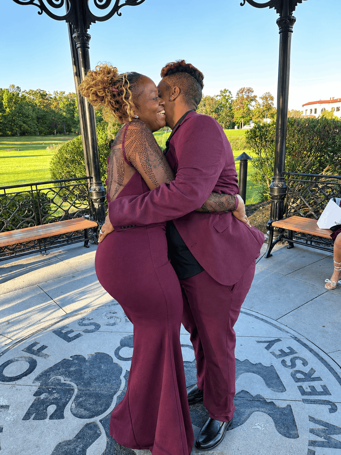 Two brides, Tiffany and Tanell, embracing beneath the gazebo at Eagle Rock Reservation in West Orange, New Jersey.