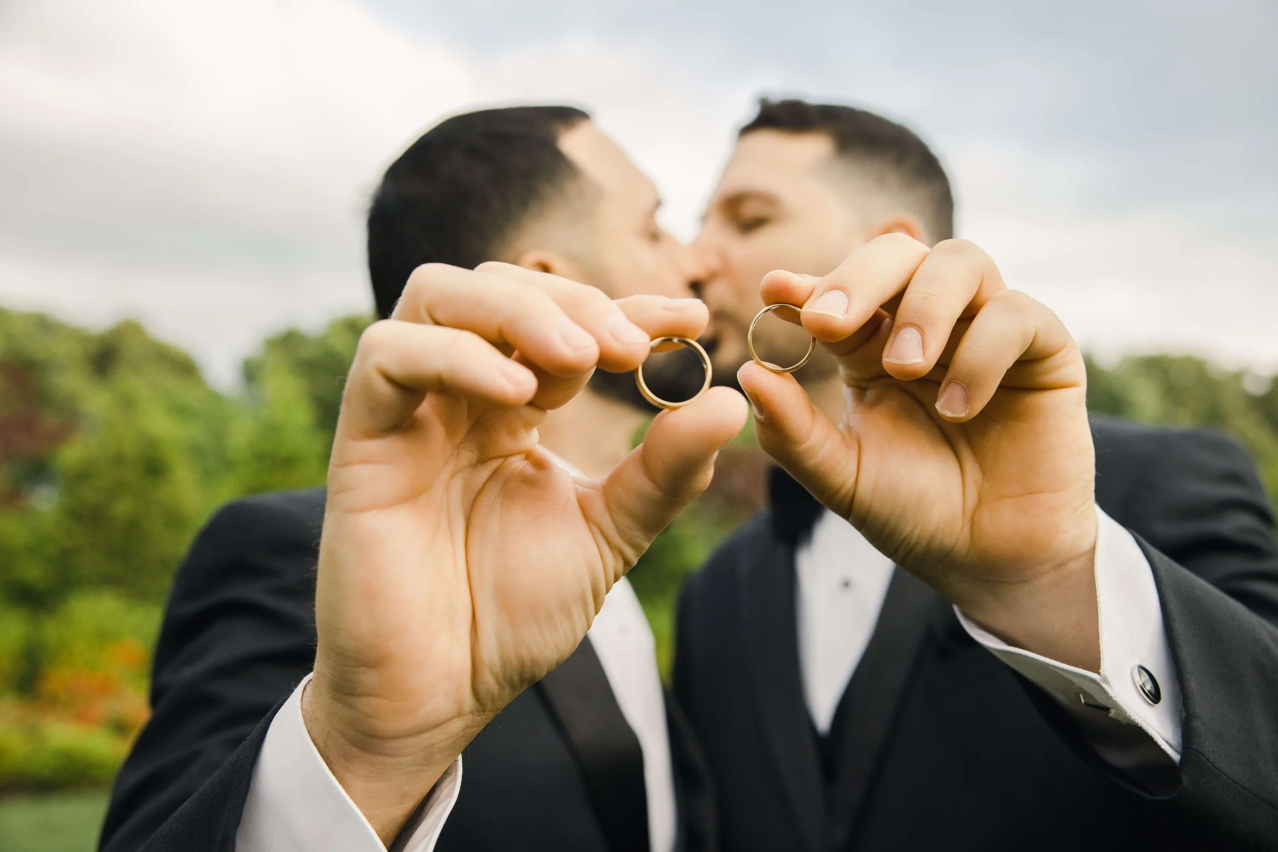 Couple holding wedding rings during an outdoor elopement ceremony in New Jersey
