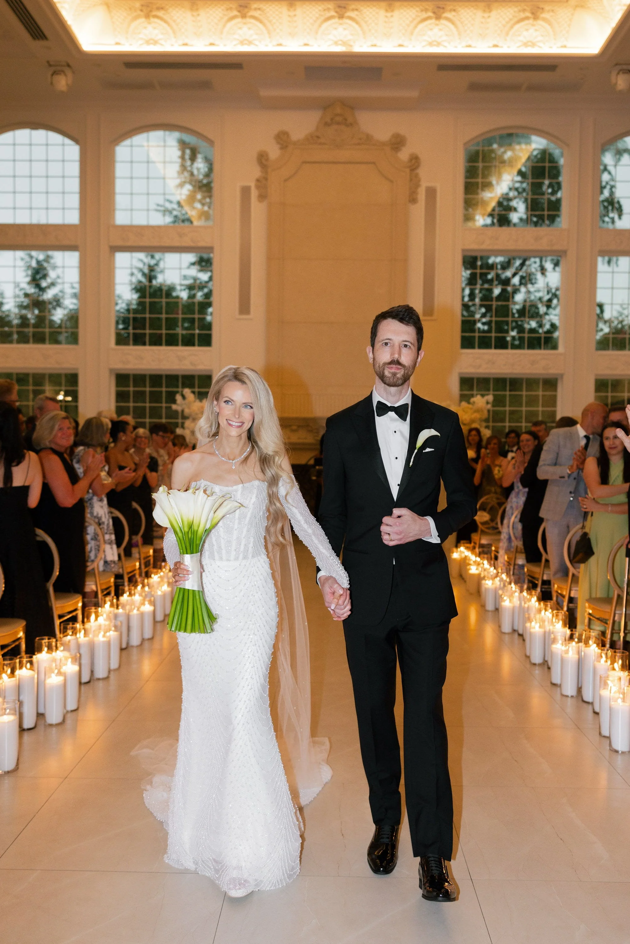 Caroline and Brett smiling as they walk back down the aisle together after their wedding ceremony at Florentine Gardens in River Vale, NJ