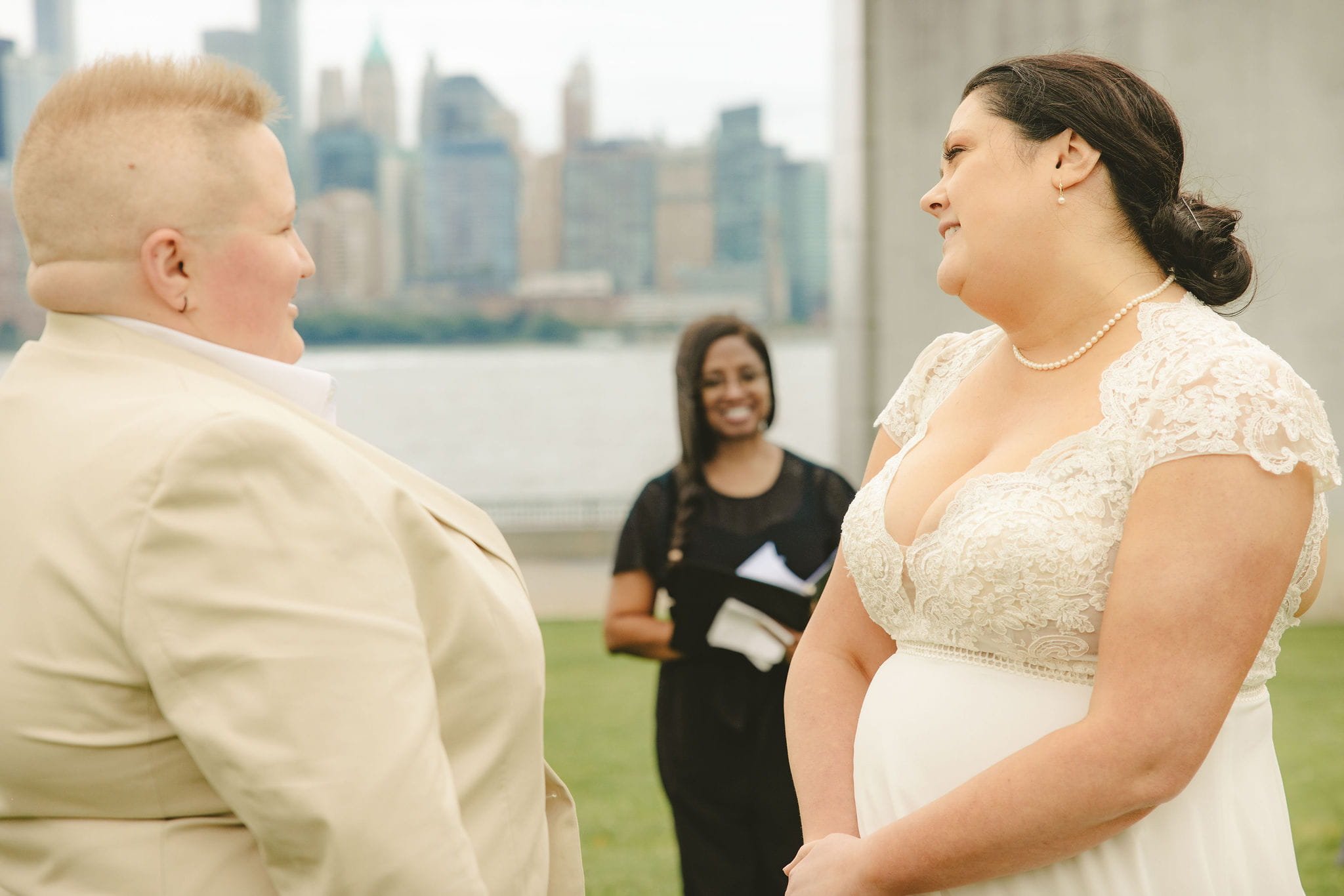 Wedding officiant leading an elopement ceremony at Liberty State Park with couple and New York City skyline in the background