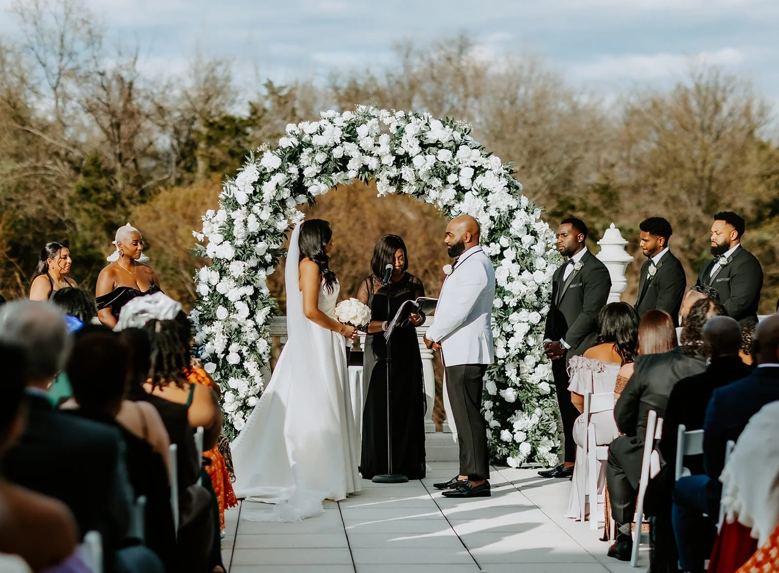 New Jersey wedding officiant Aretha Gaskin performing an outdoor wedding ceremony for a bride and groom surrounded by their wedding party and guests