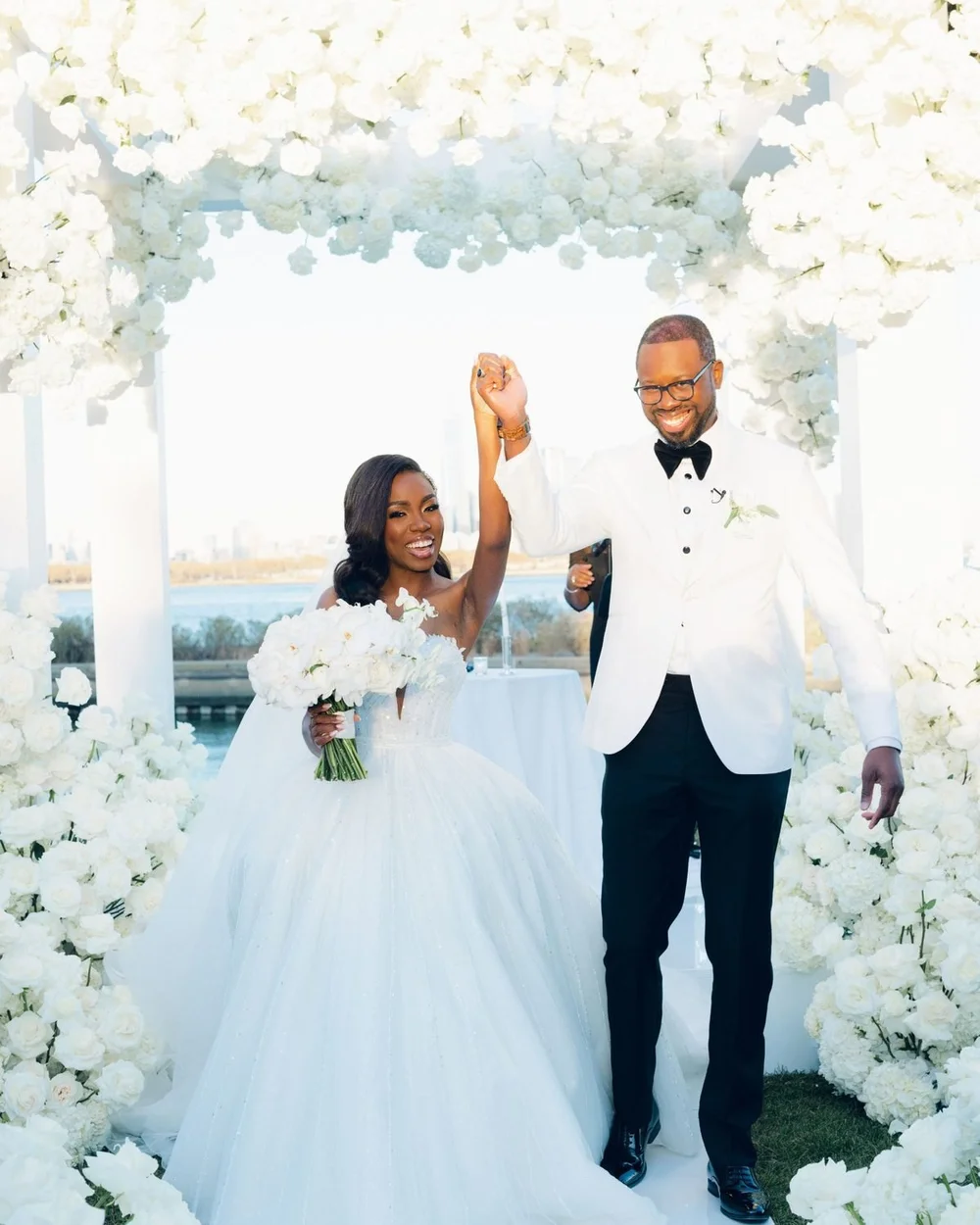 Starr and Nygel celebrate under a white floral canopy at Hudson House in Jersey City, NJ