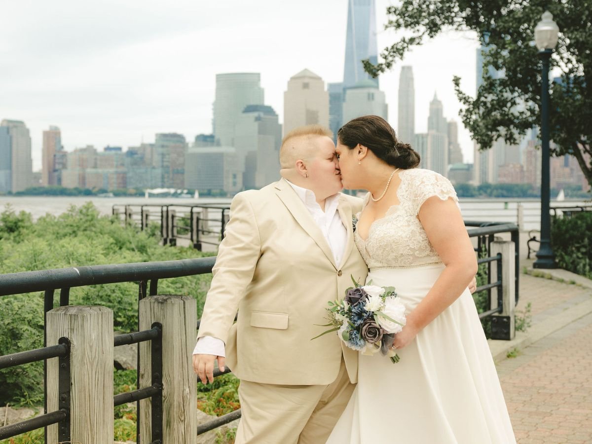 Couple sharing a kiss during their Liberty State Park elopement with the New York City skyline in the background