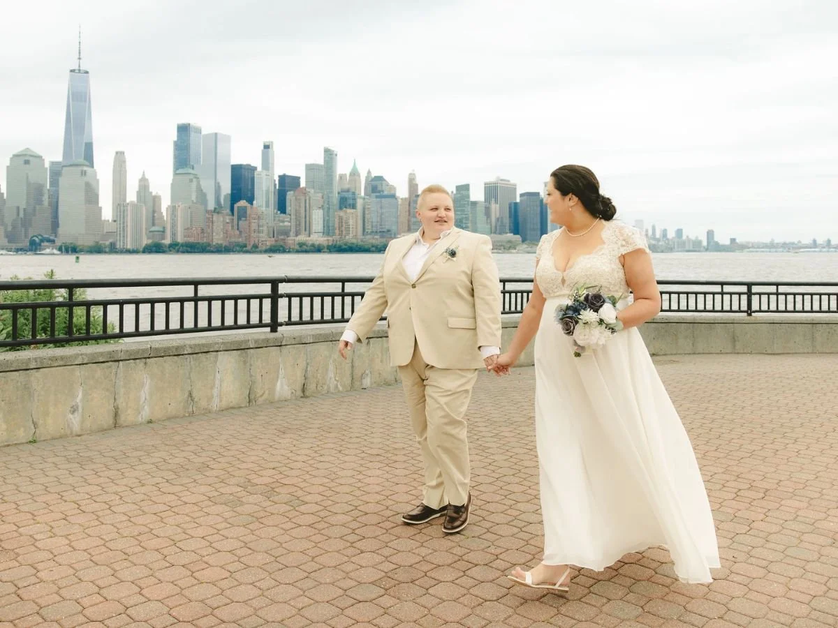 Couple walking together after their elopement at Liberty State Park with the New York City skyline in the background