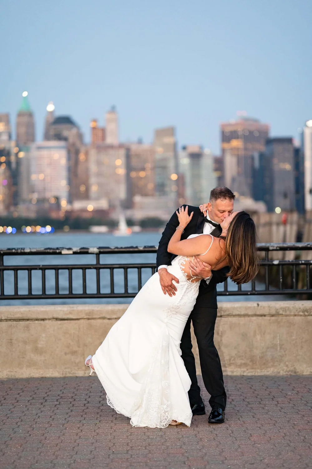 Stacey and Anthony share a dip kiss with the Manhattan skyline behind them at Liberty State Park