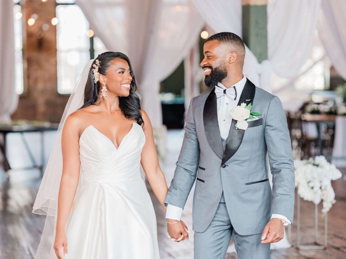 Bride and groom smiling at each other as they walk hand in hand through The Art Factory in Paterson, NJ