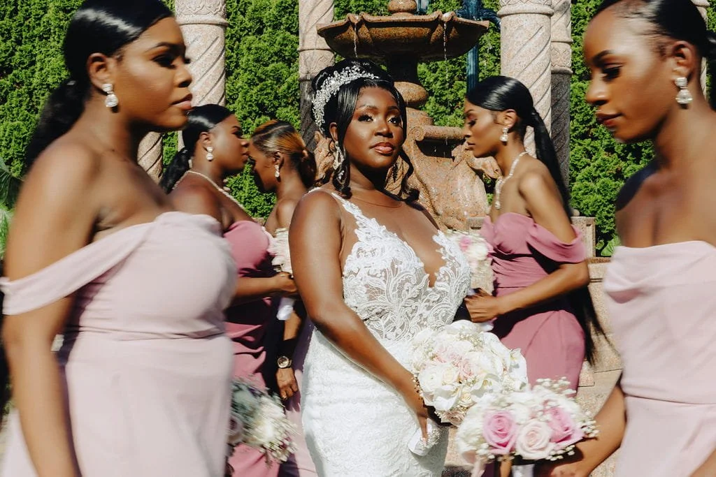 Kristie surrounded by her bridesmaids during a candid wedding party portrait at Sand Castle in Franklin Square, NY
