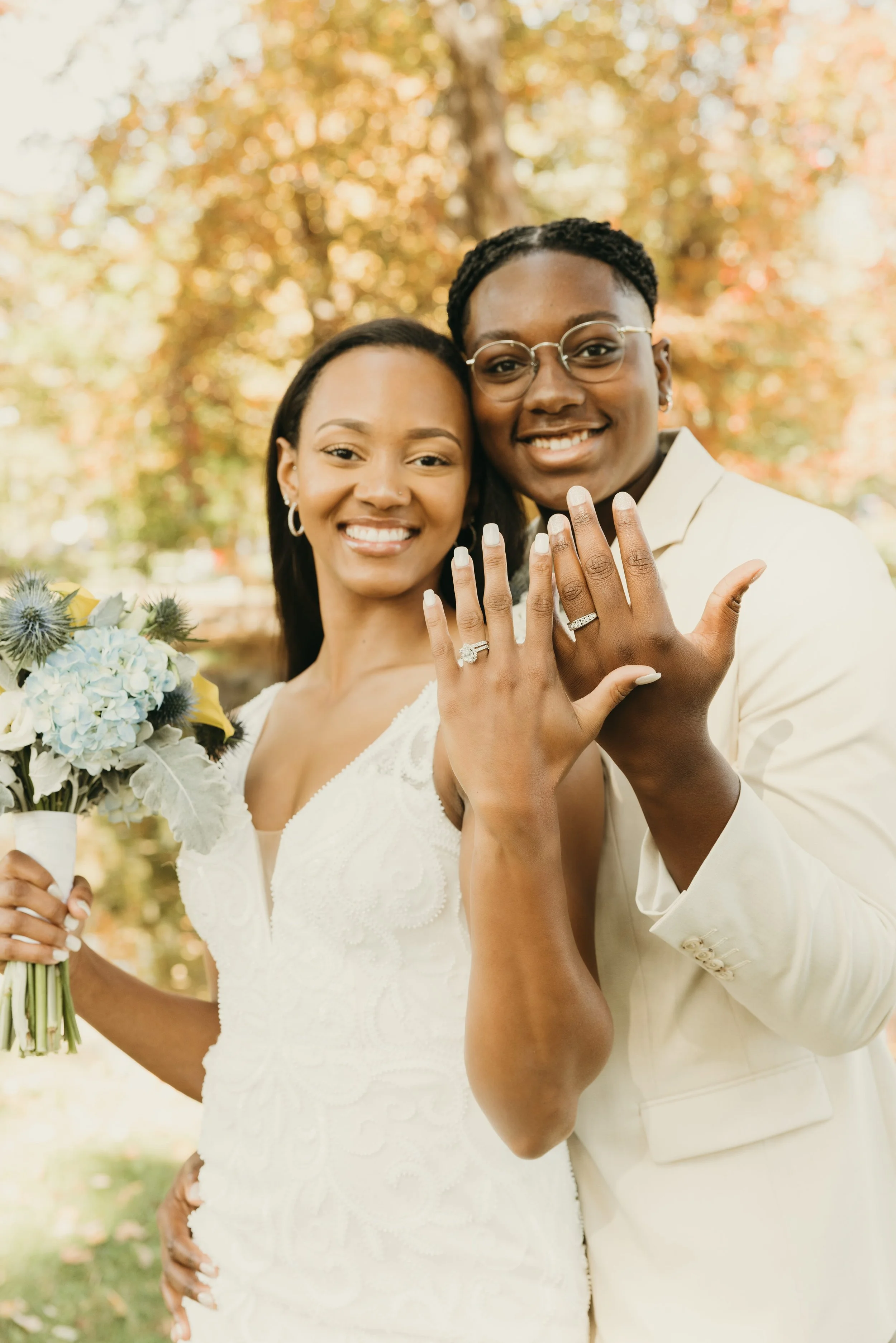 Jaide and Amiaya smile and show their wedding rings after their fall wedding ceremony at Mindowaskin Park in Westfield, NJ.
